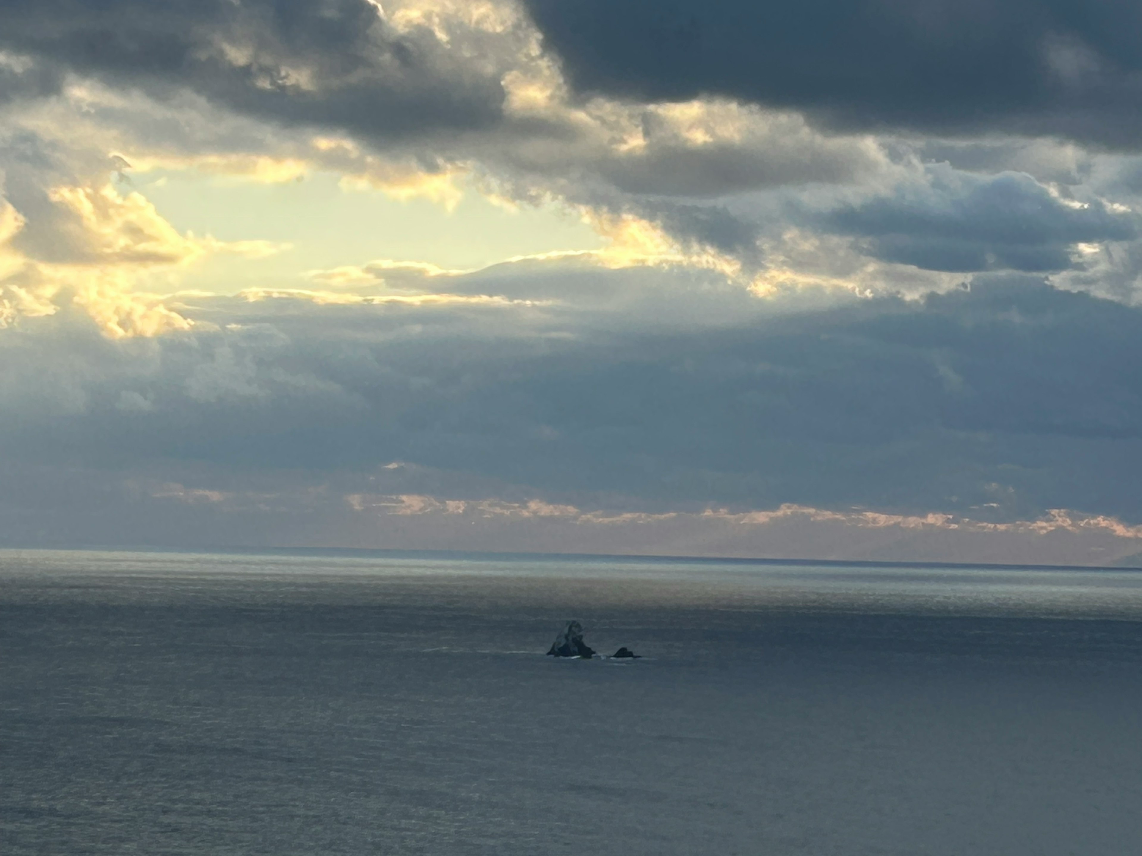 Paysage maritime avec des nuages et des îlots lointains visibles