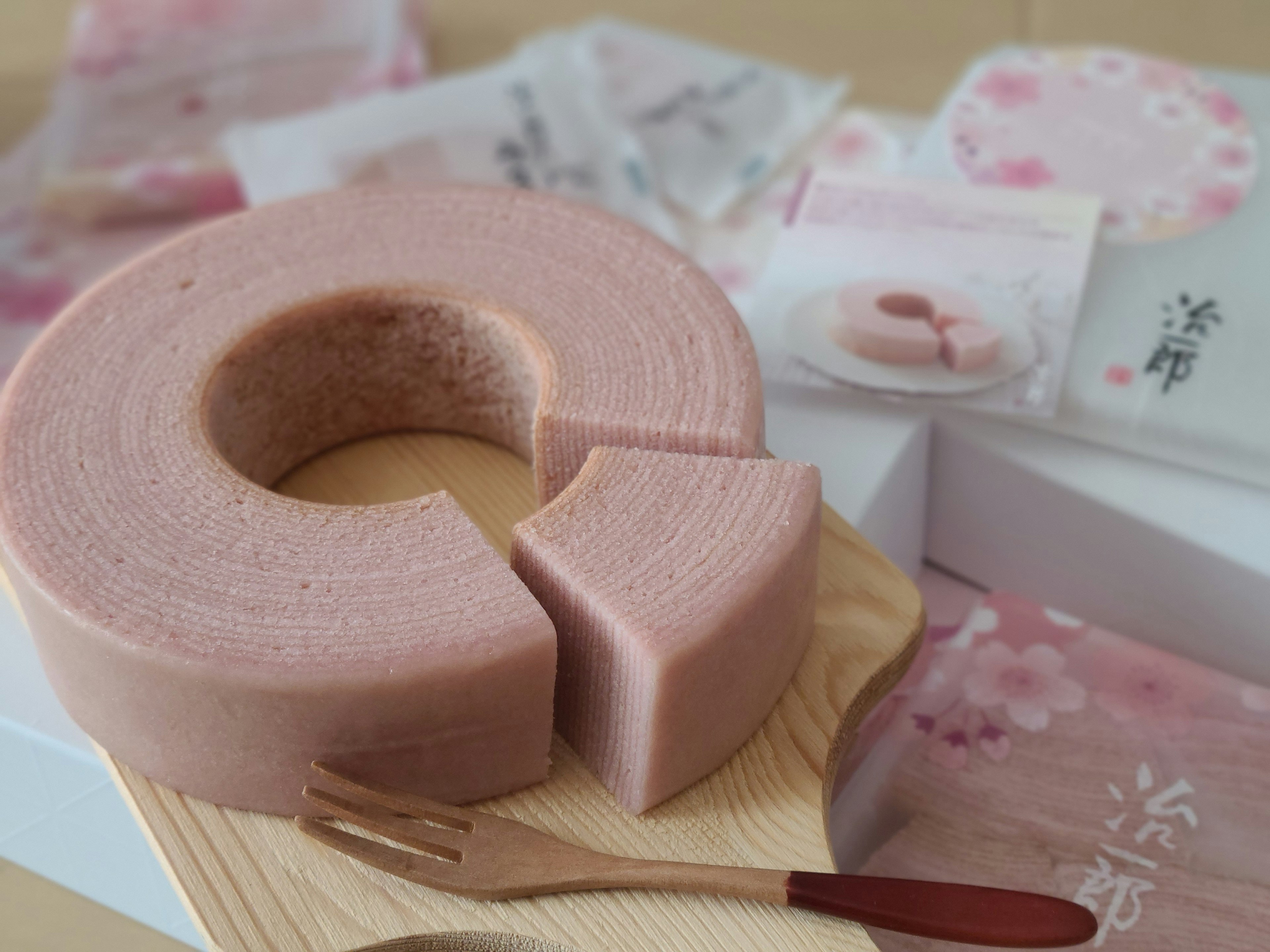 Sliced cherry blossom flavored Baumkuchen on a wooden plate with decorative packaging