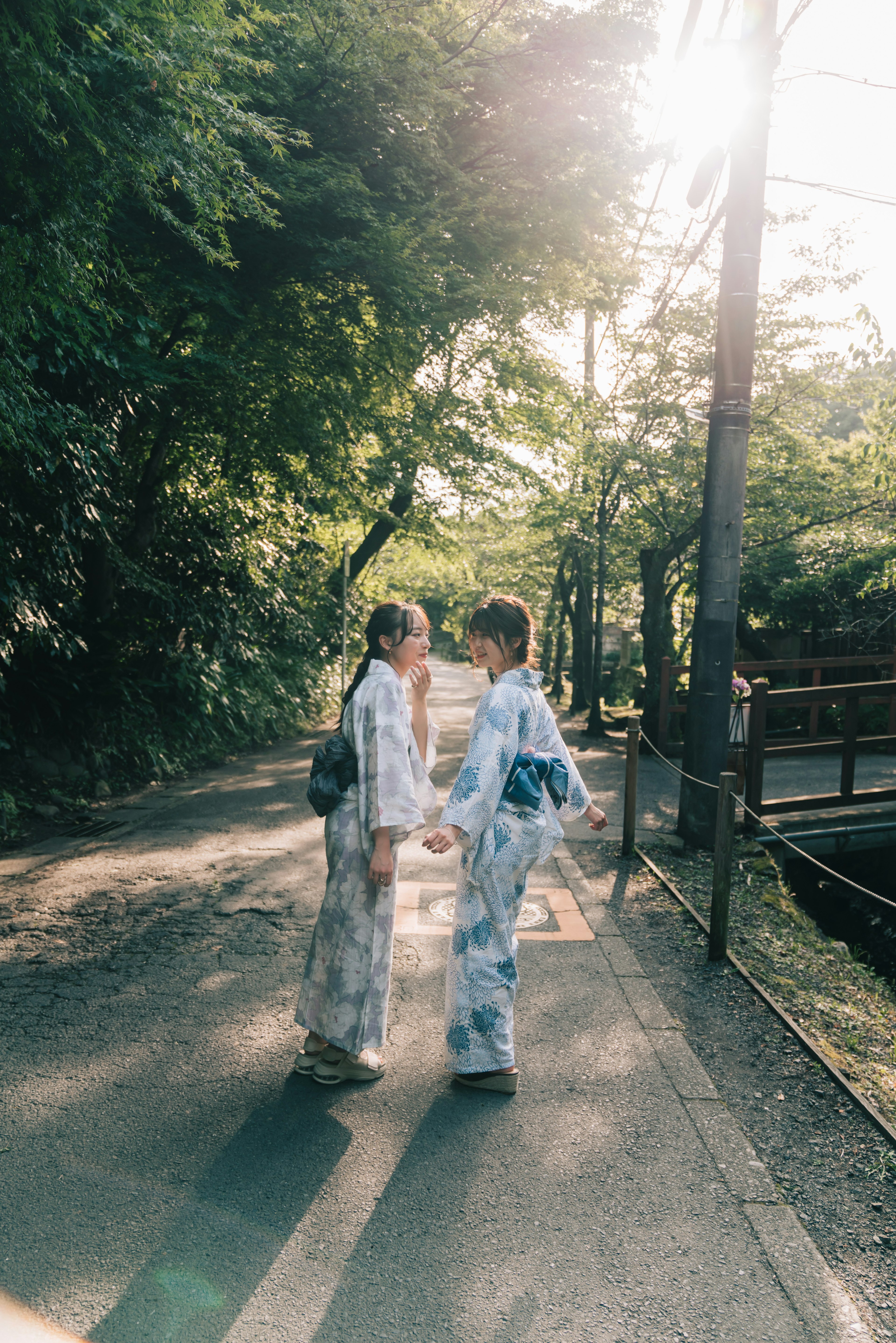 Hai bạn trẻ mặc yukata đối mặt nhau trong khung cảnh tự nhiên