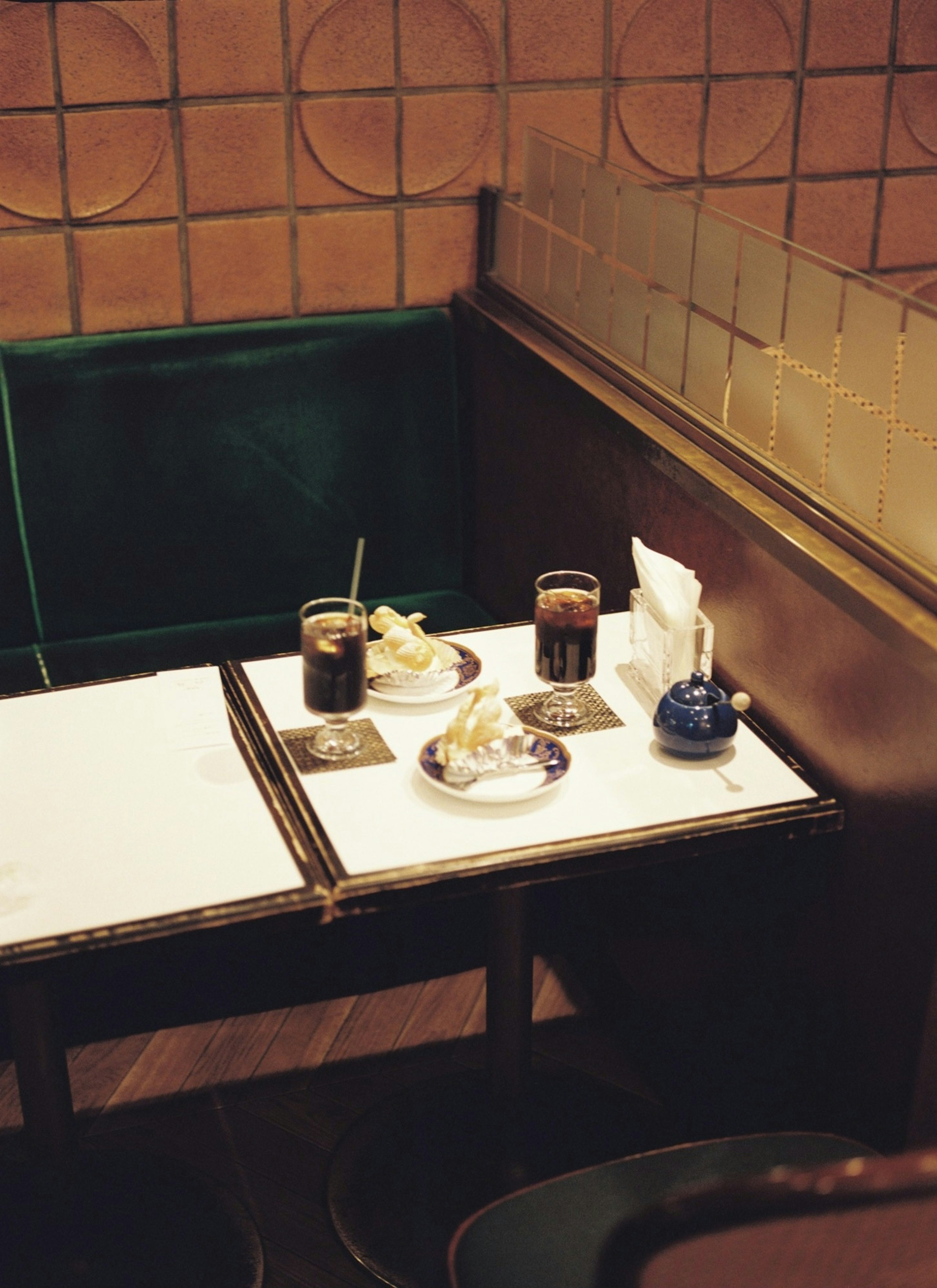 A cozy cafe corner featuring a small table with drinks and dishware