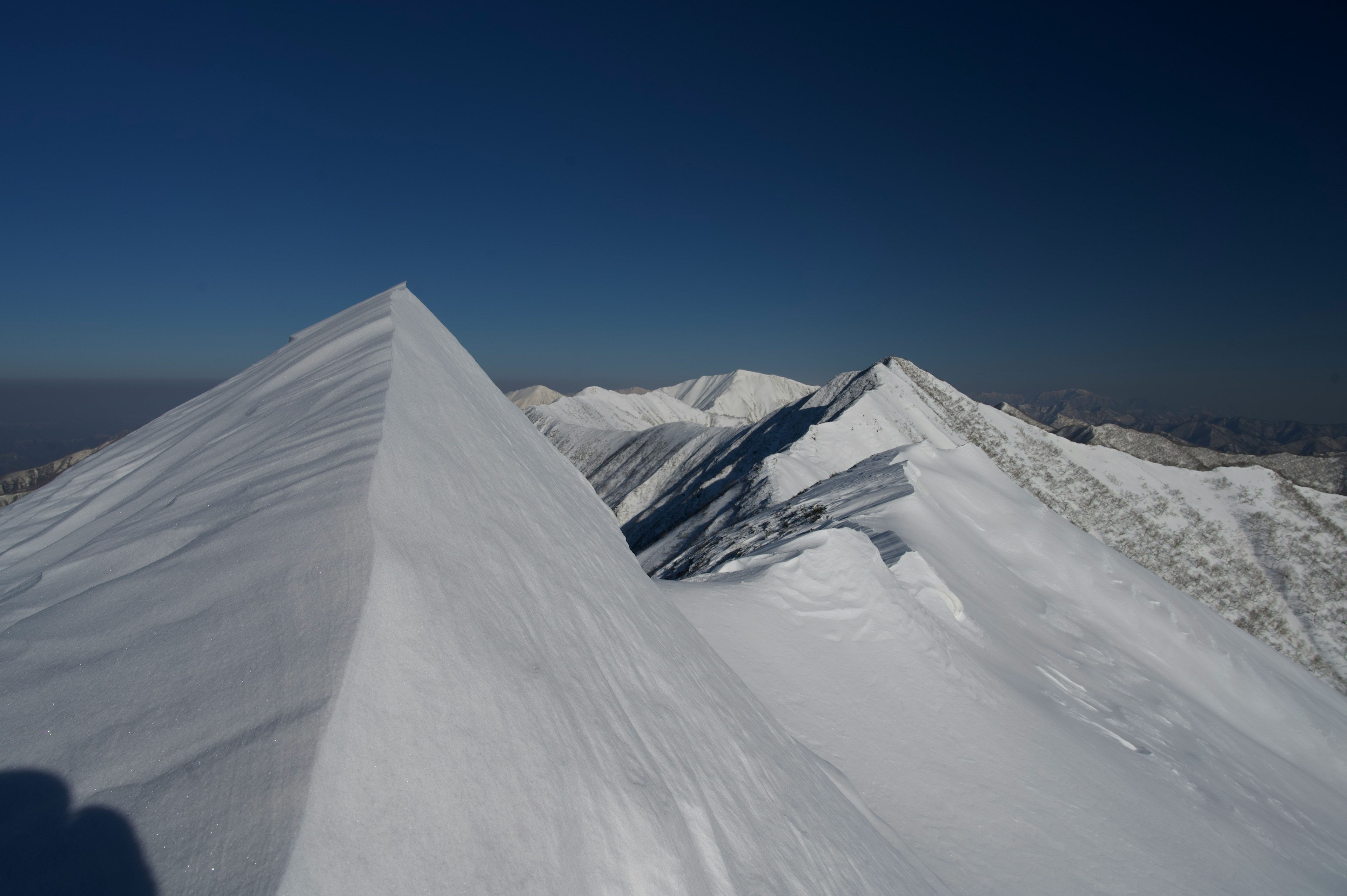 雪に覆われた山の峰が連なる壮大な風景