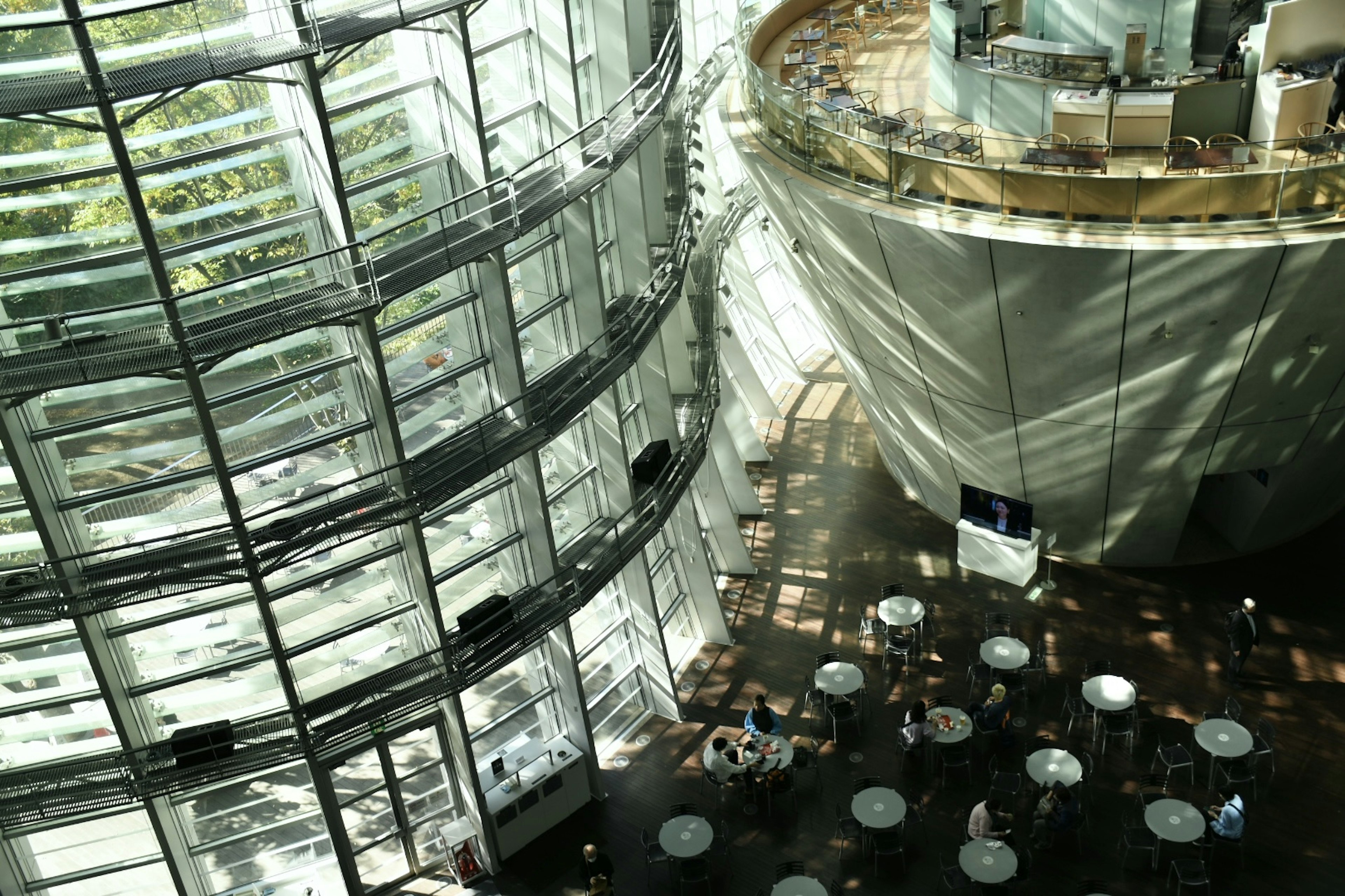 Vue intérieure d'un bâtiment moderne en verre avec lumière naturelle et design circulaire