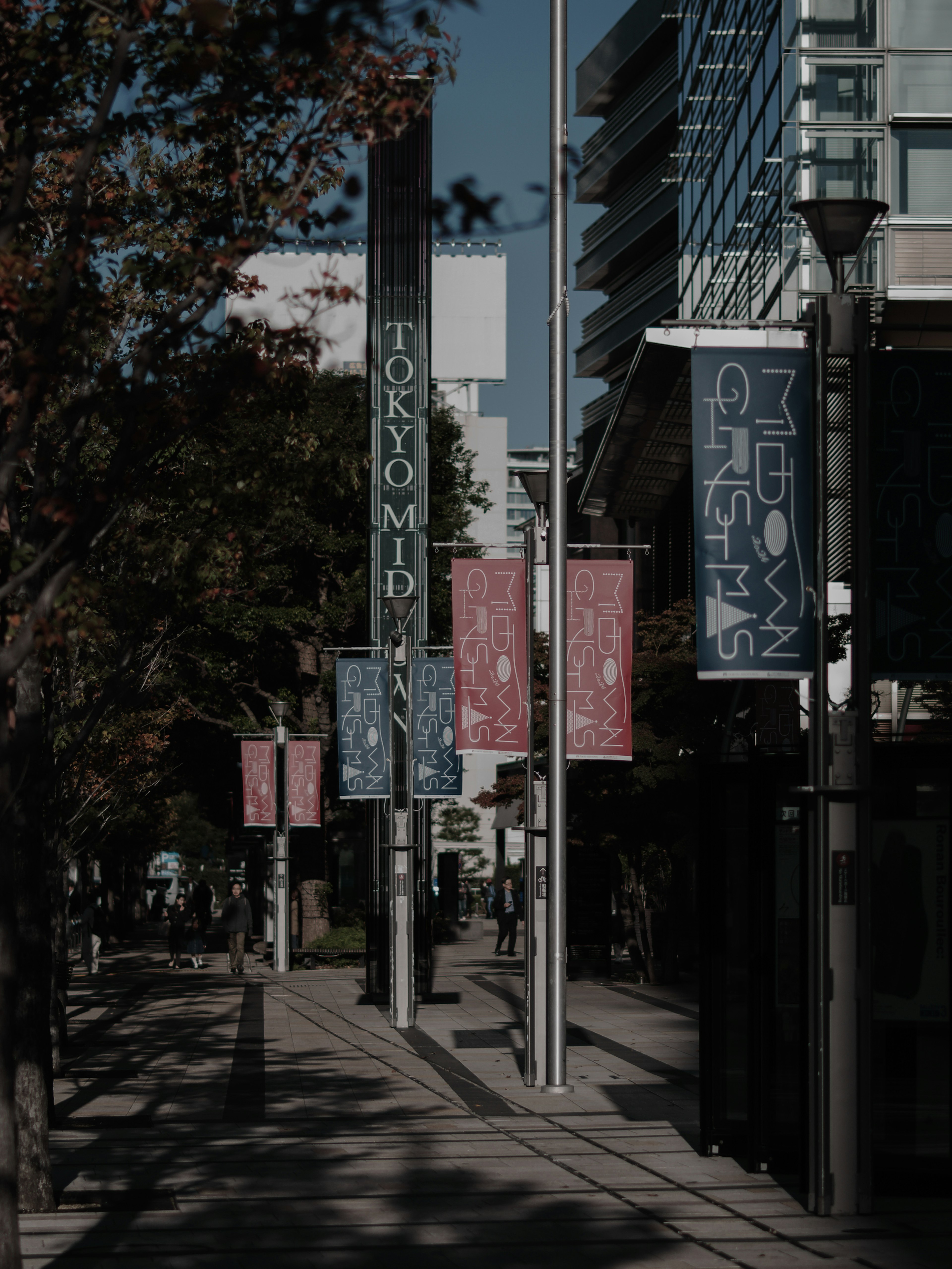 Vista de la calle de Tokyo Midtown con pancartas coloridas a lo largo de la acera