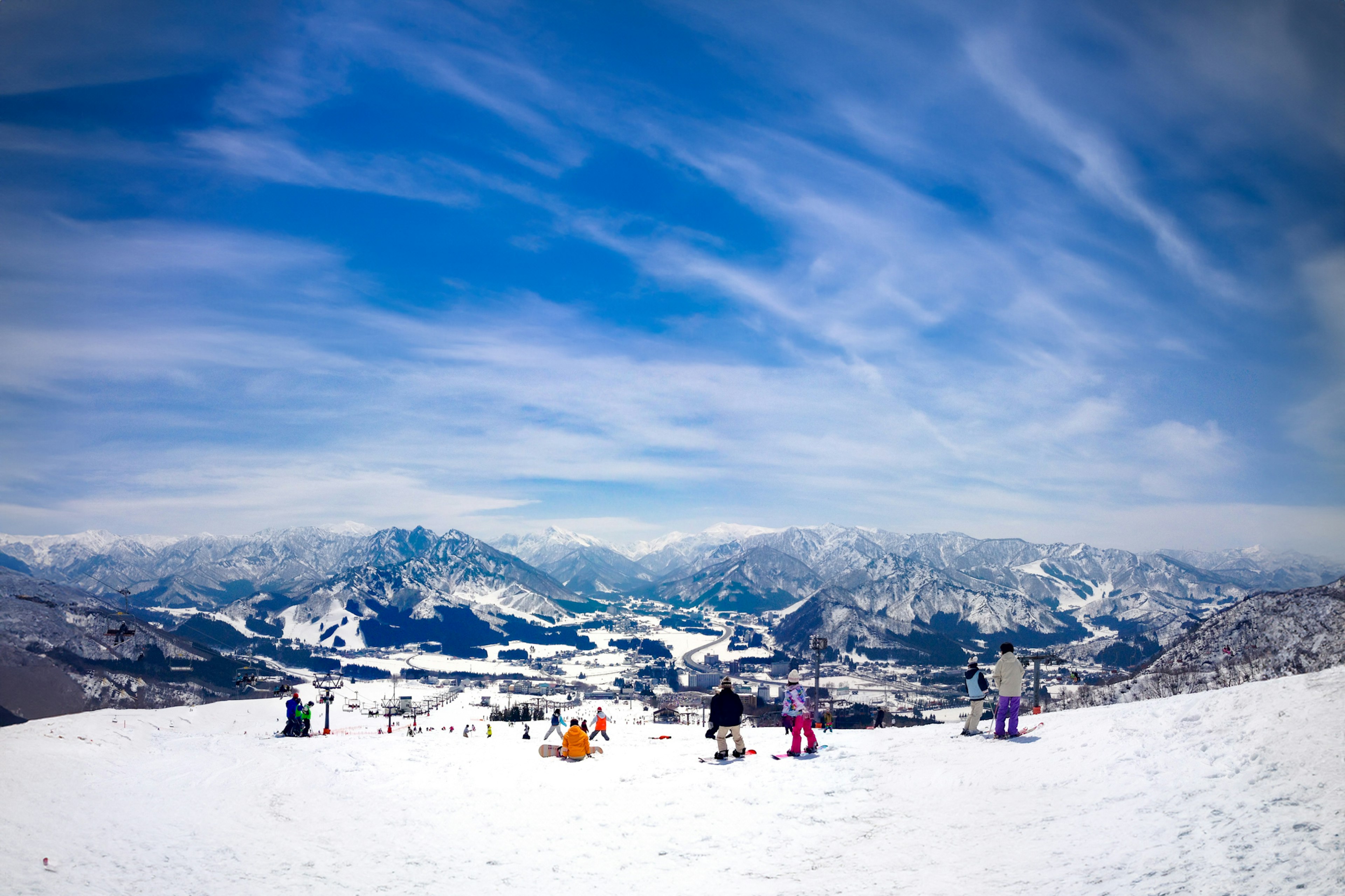 Skifahrer genießen schneebedeckte Berge unter einem blauen Himmel