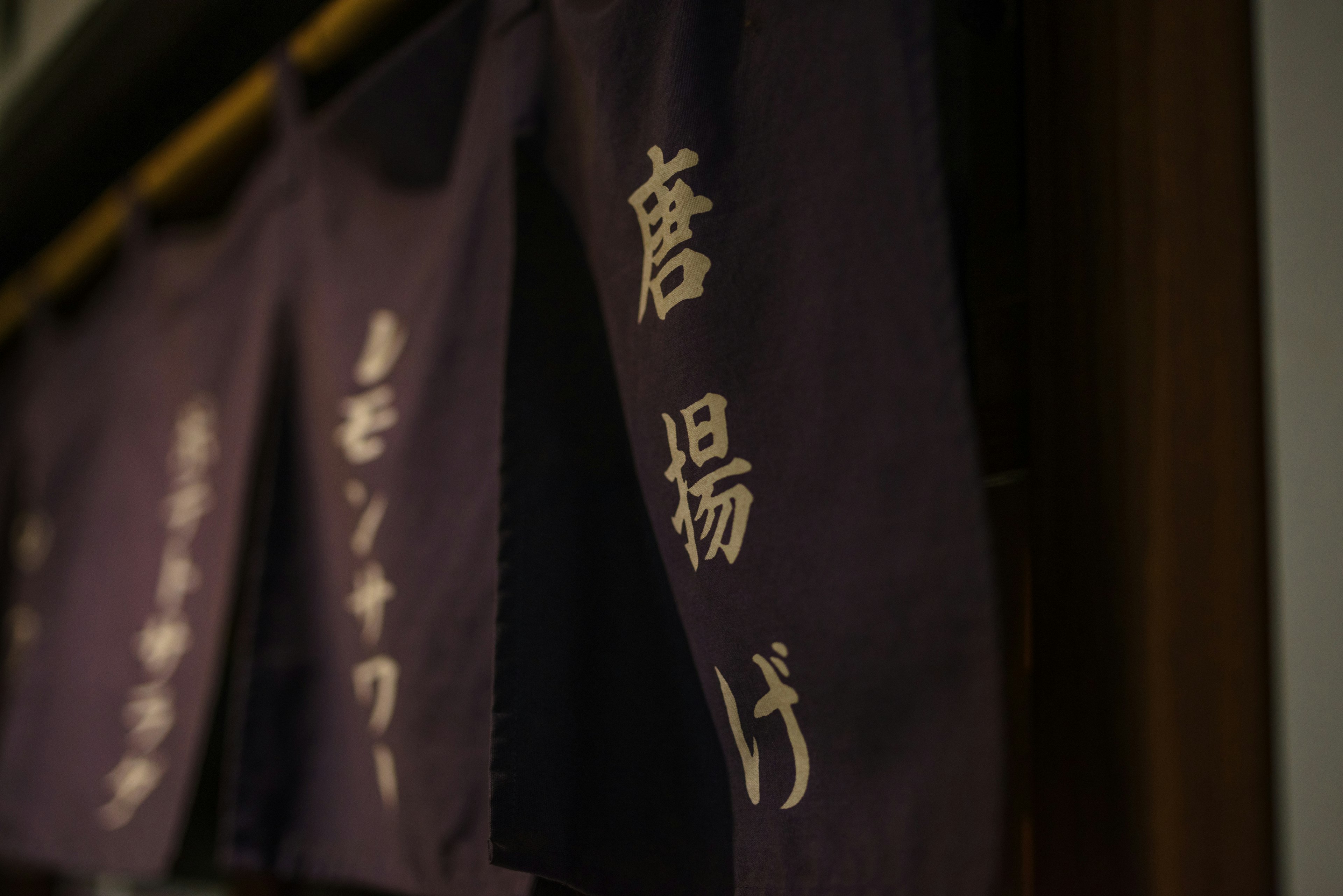 Purple noren with gold lettering in a traditional Japanese style