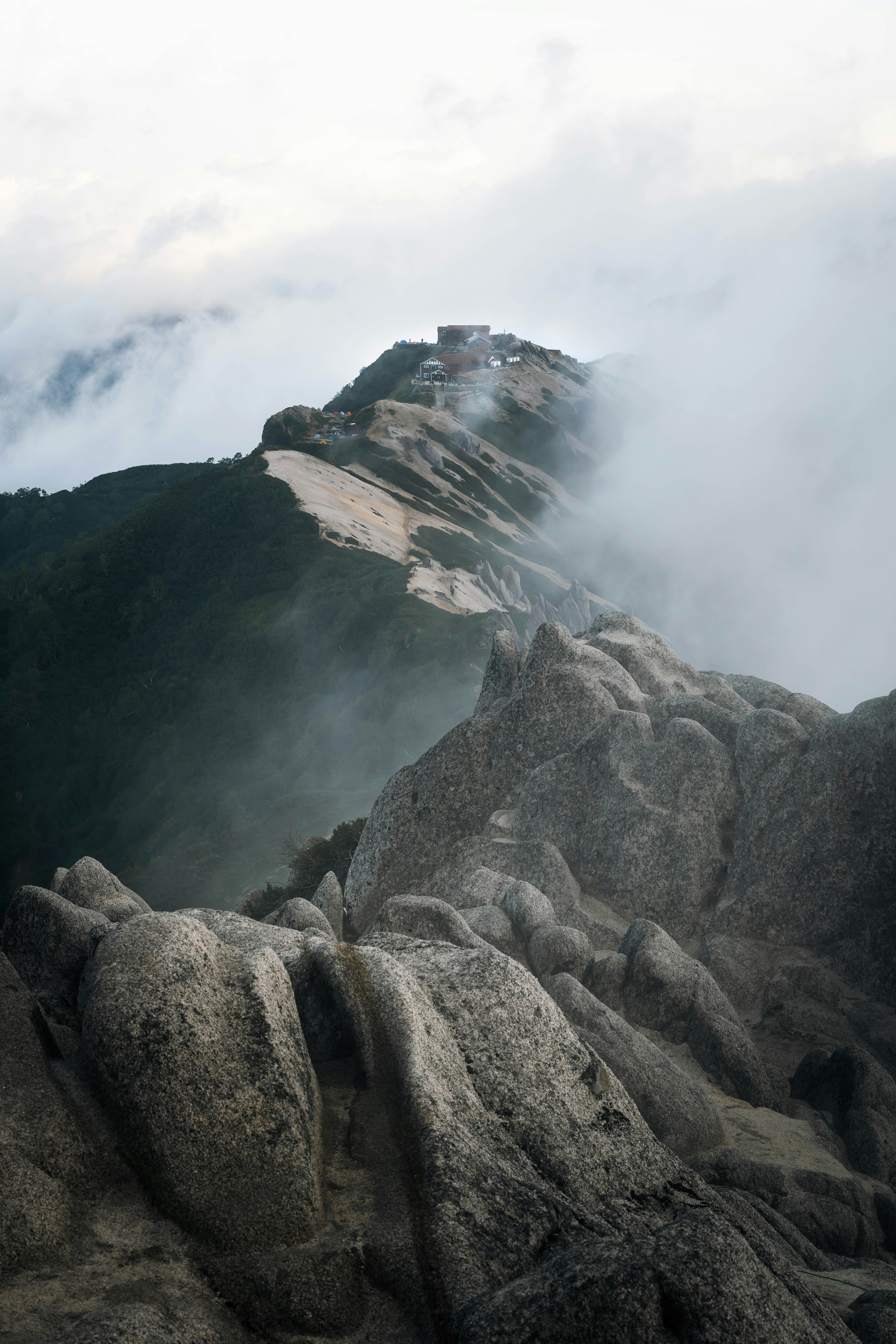 gerölliger Gebirgslandschaft mit hohen Felsen in Wolken gehüllt