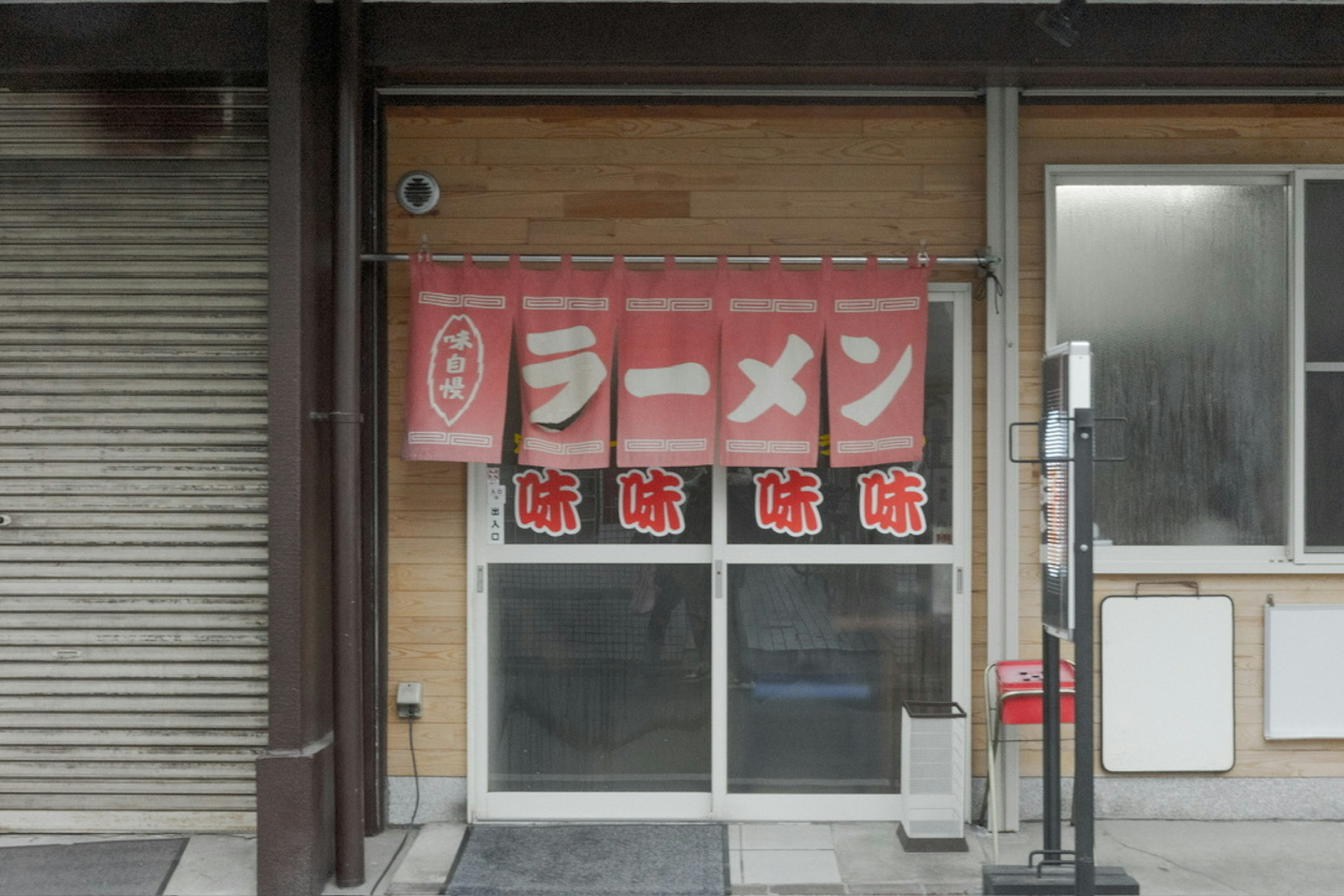 赤い暖簾にラーメンの文字がある日本のラーメン店の外観