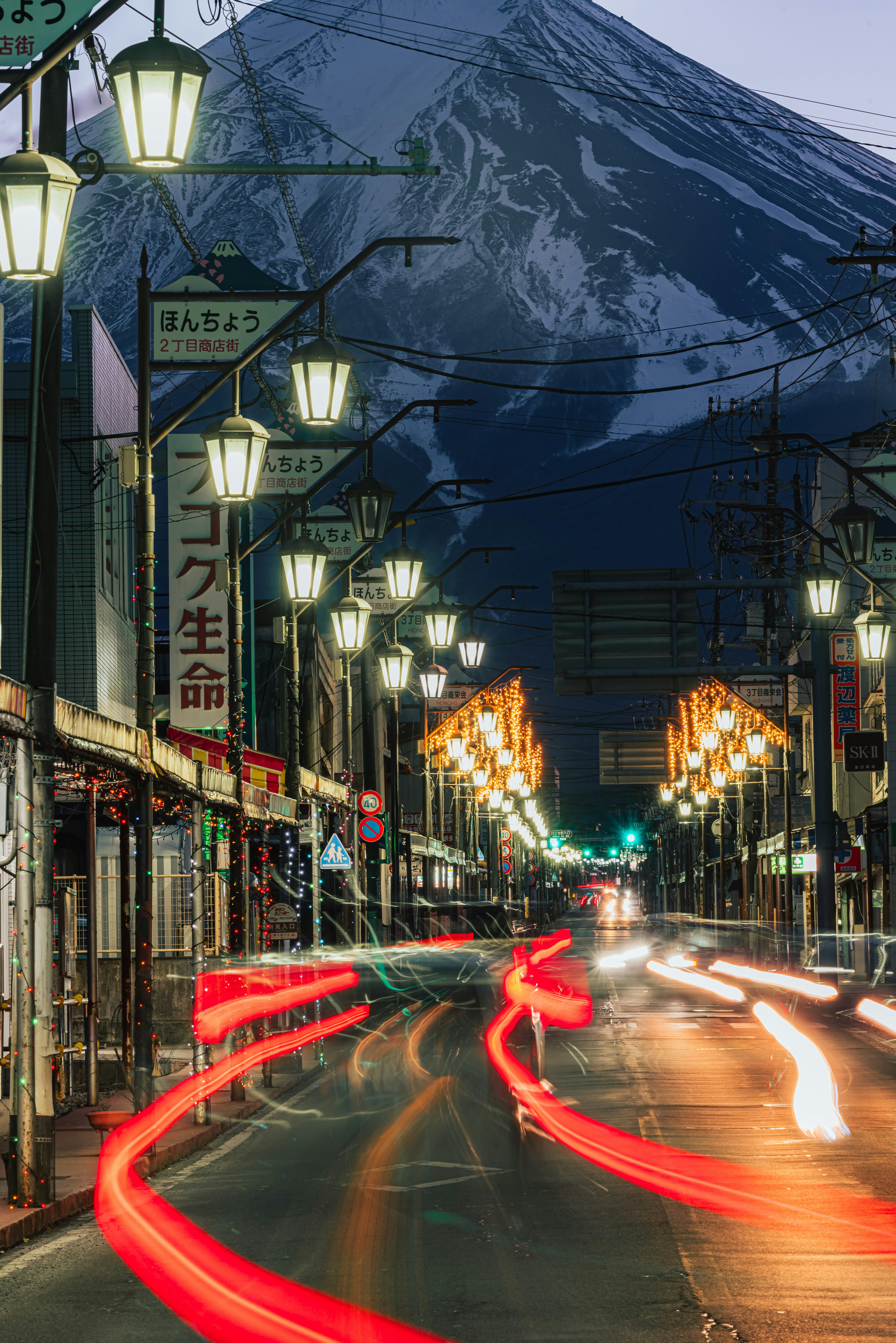 Scène de rue nocturne avec lampadaires et le mont Fuji en arrière-plan