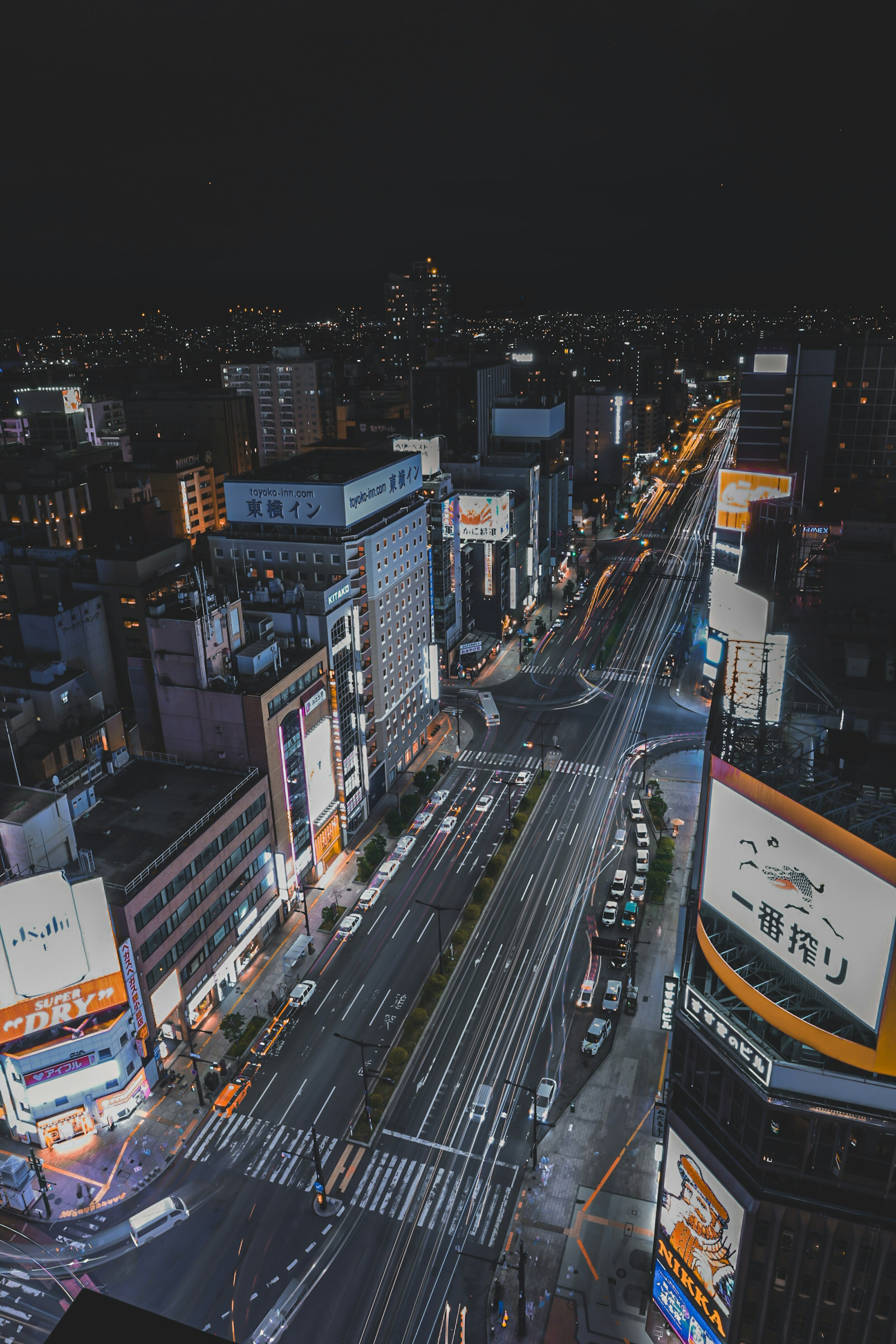 Night view of a bustling city with high-rise buildings and illuminated streets