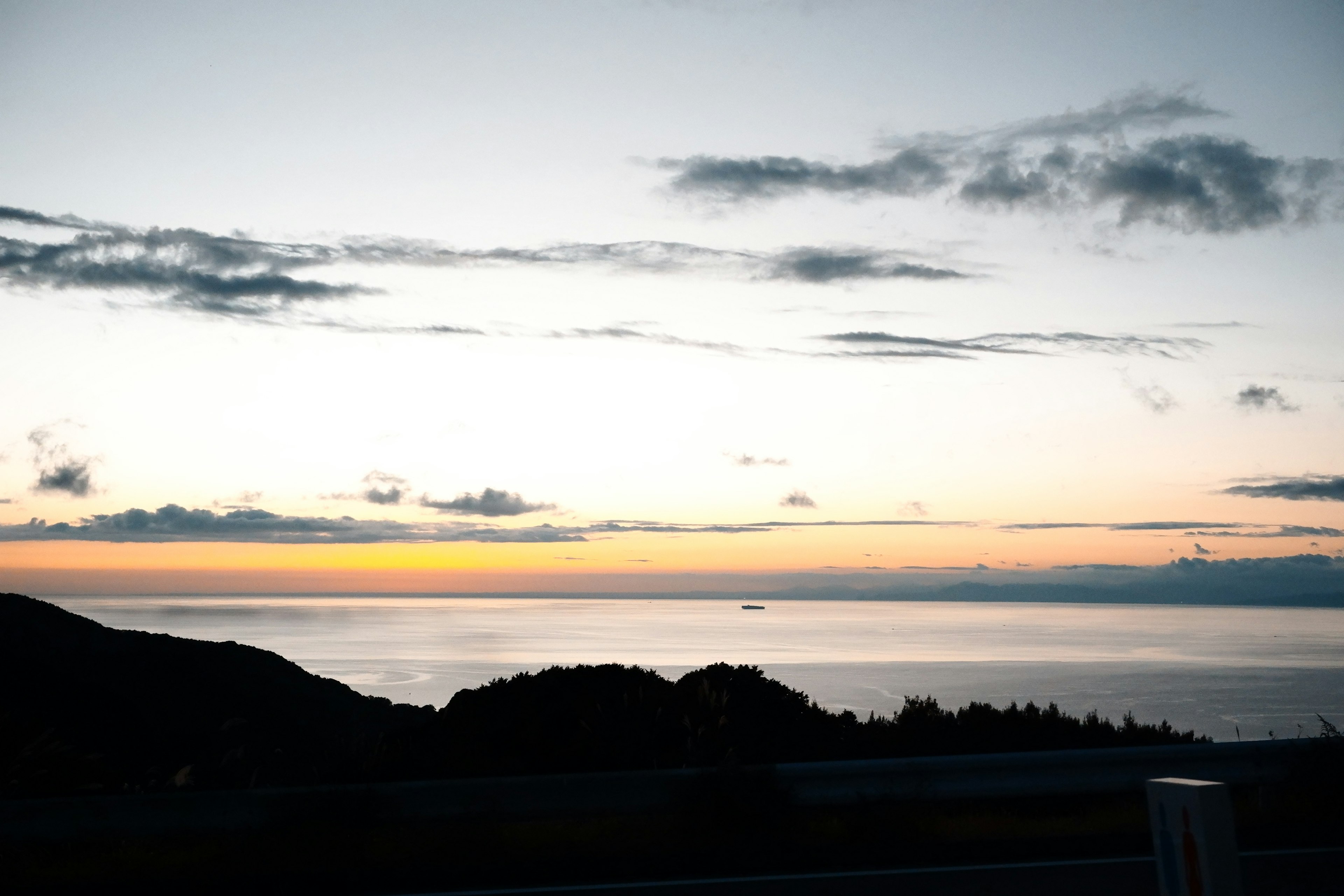 美しい夕焼けの海の景色と雲のシルエット