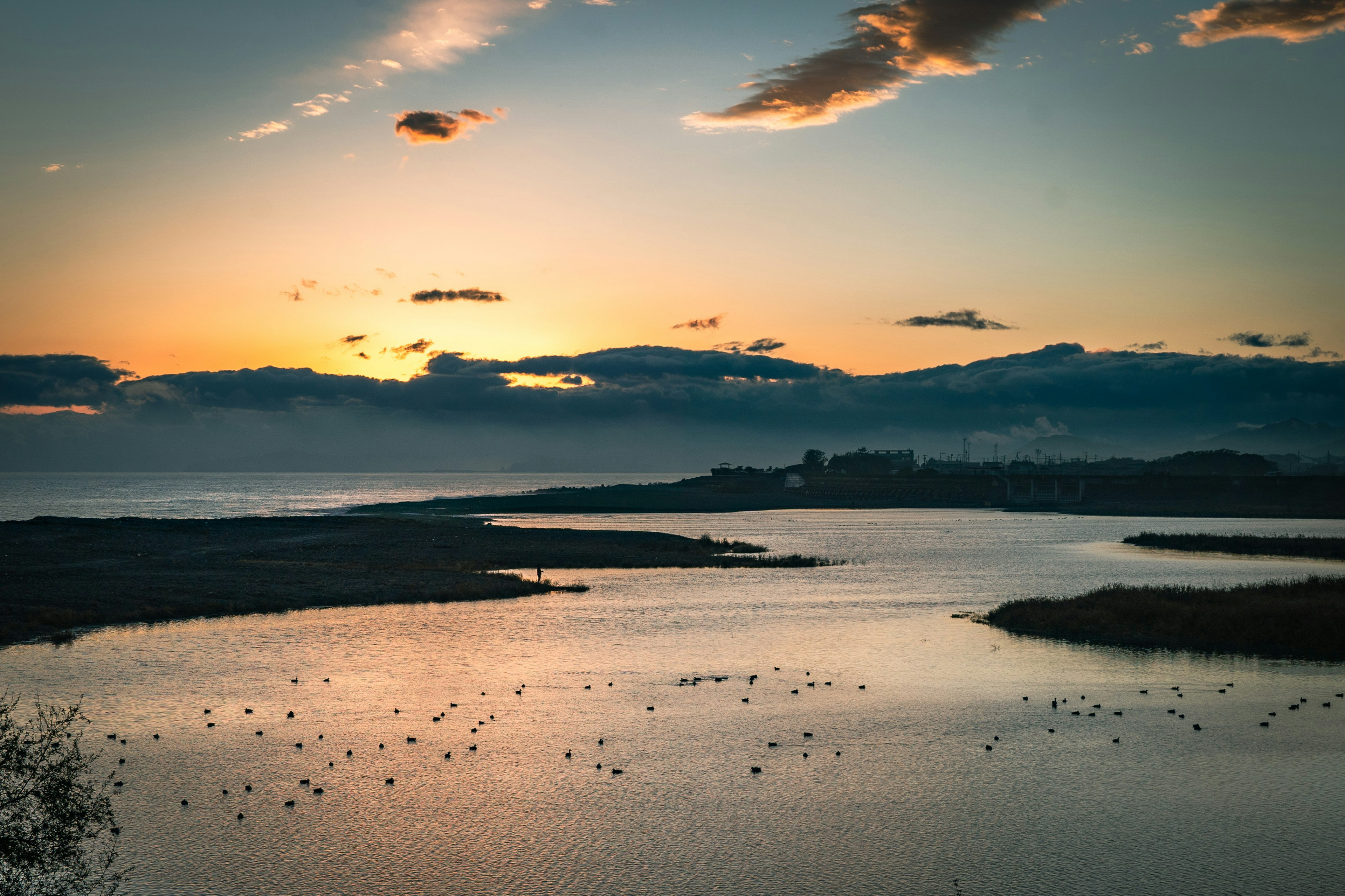 夕日が沈む海と静かな川の美しい風景