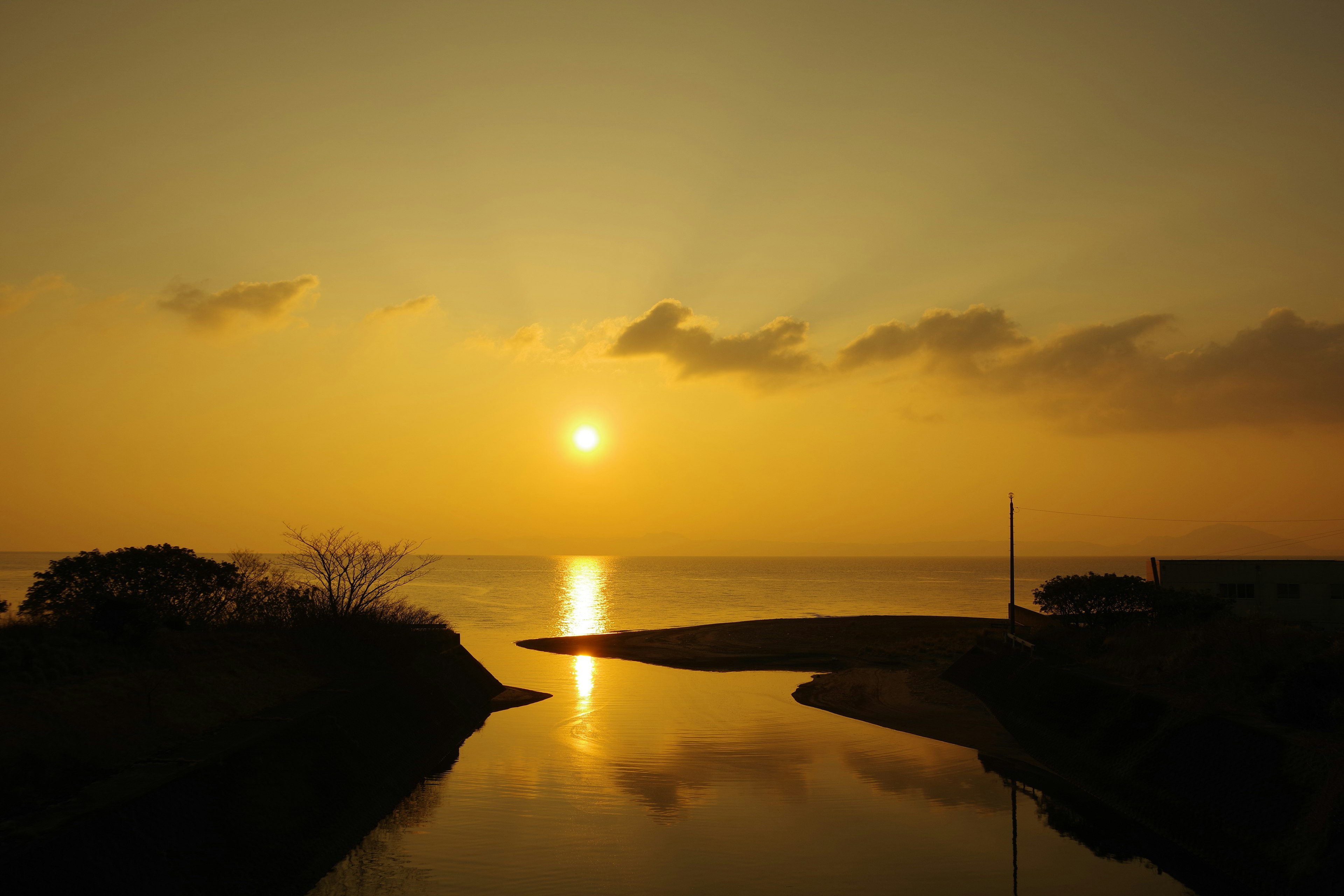 Paesaggio marino tranquillo con il sole che tramonta riflesso sull'acqua