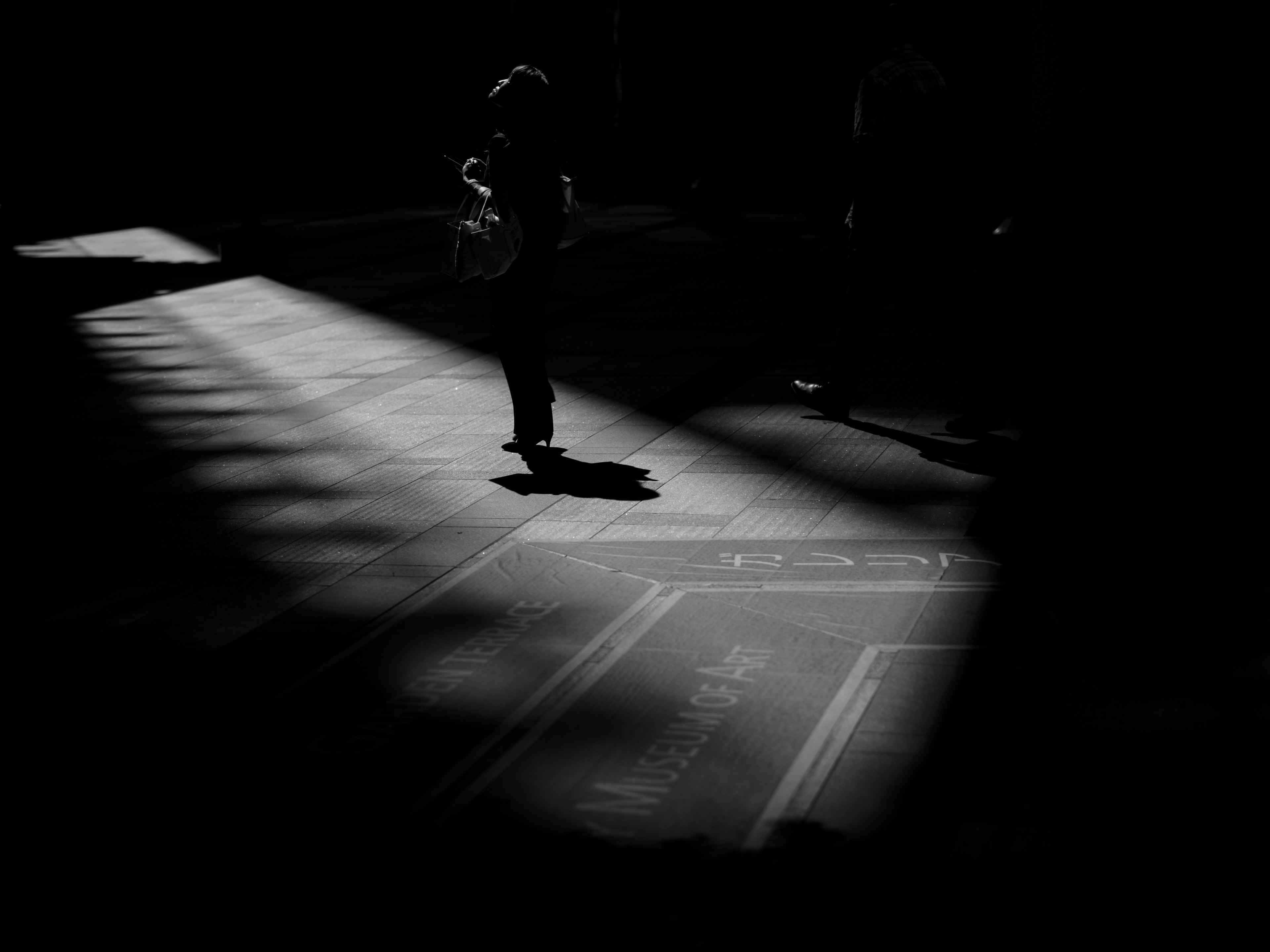 Silhouette of a person standing in a beam of light in a dark space