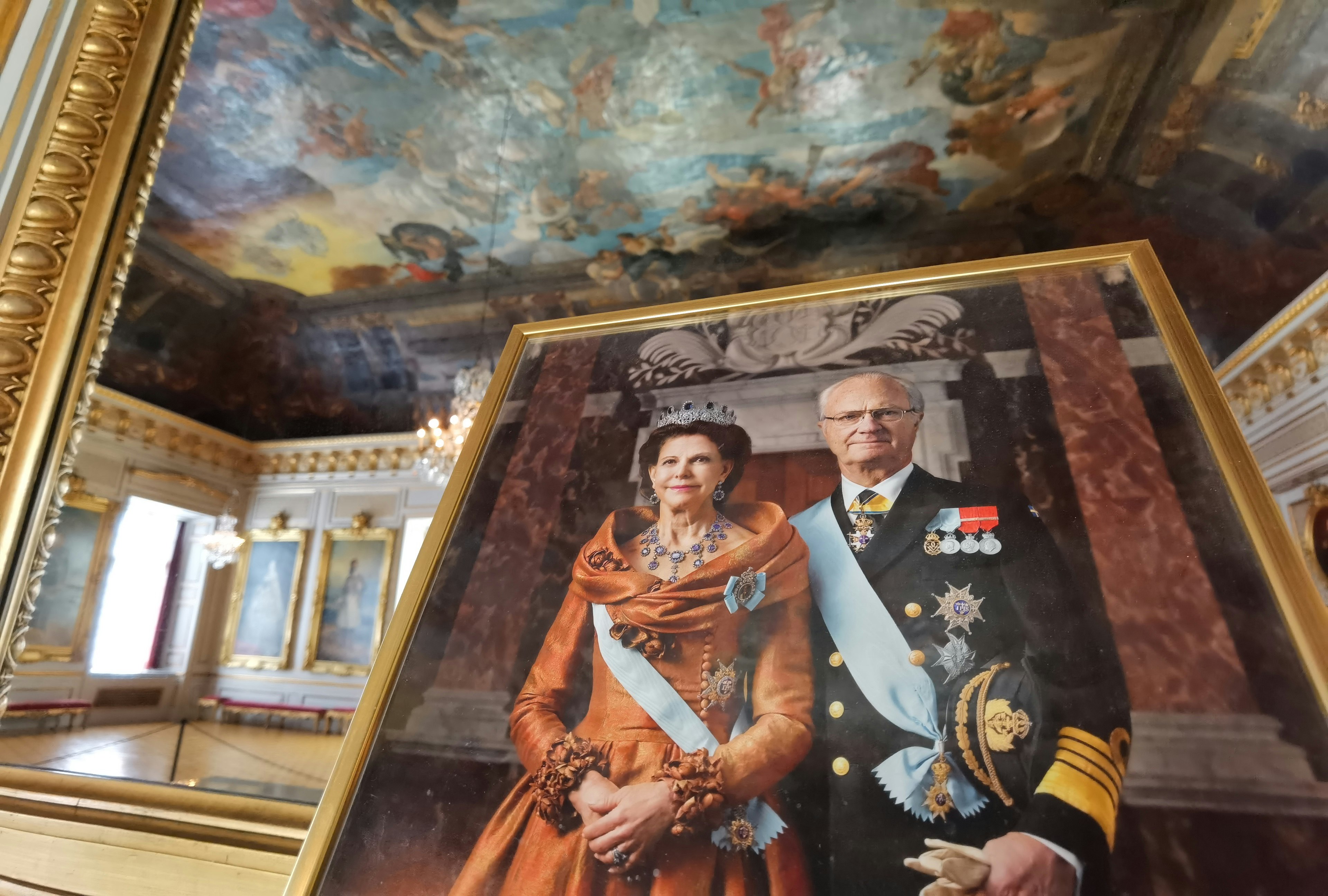 Interior of a luxurious room featuring a royal portrait