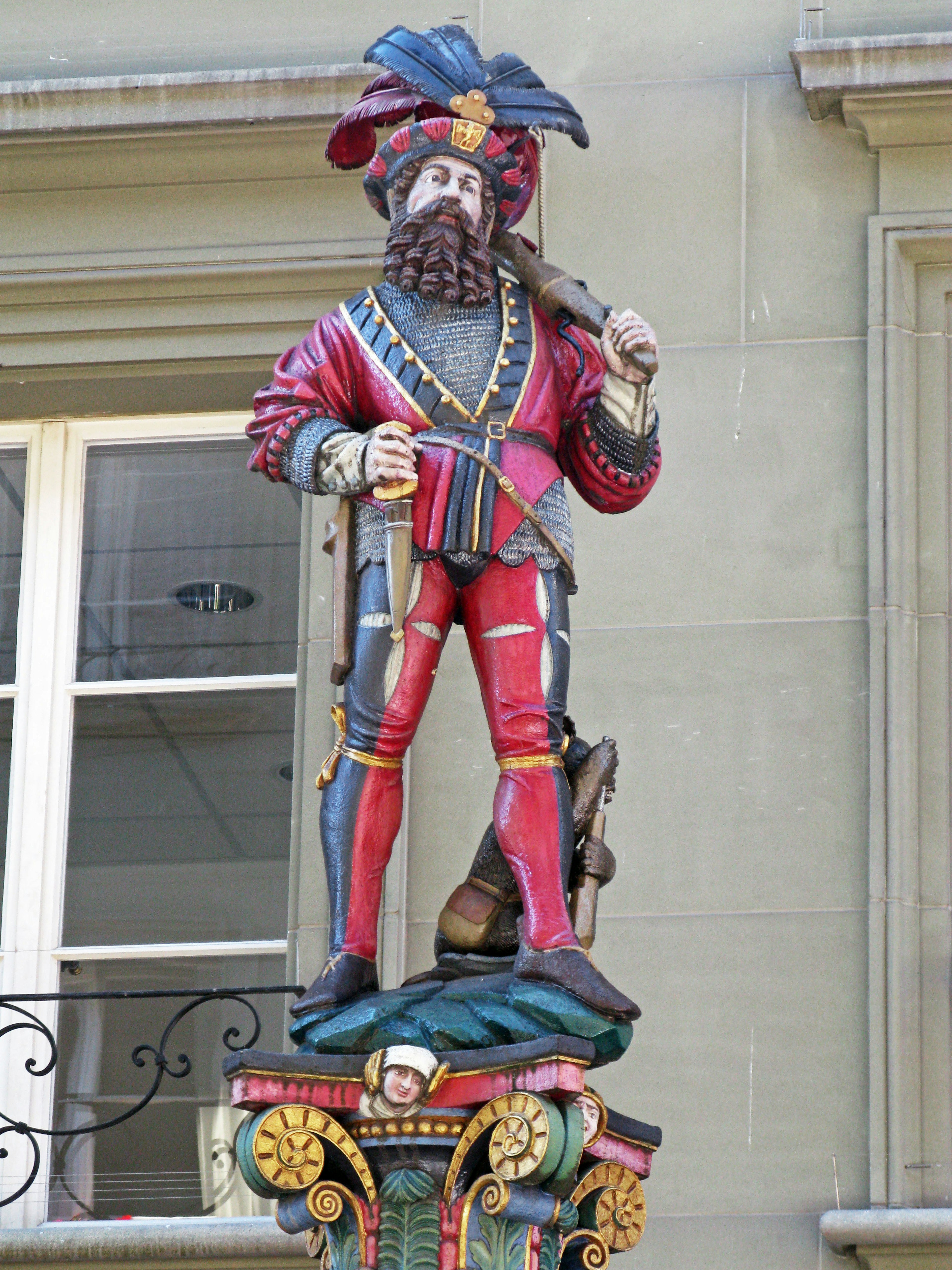 Eine bunte Statue eines Mannes in aufwendiger Kleidung, der ein Schwert hält und einen Hut trägt