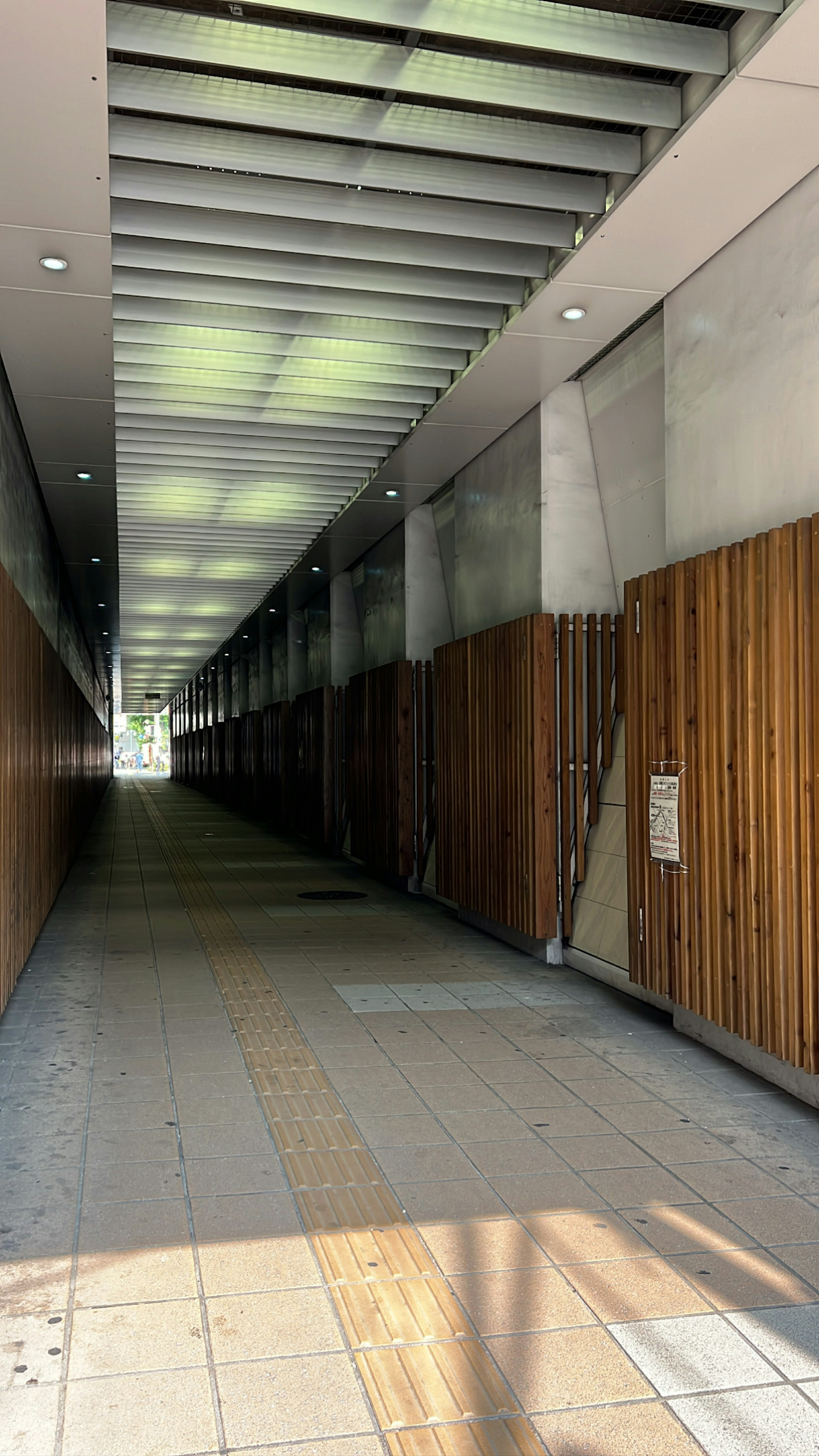 Langer Flur mit Holz- und Betonwänden Helles Licht und Schattenkontraste