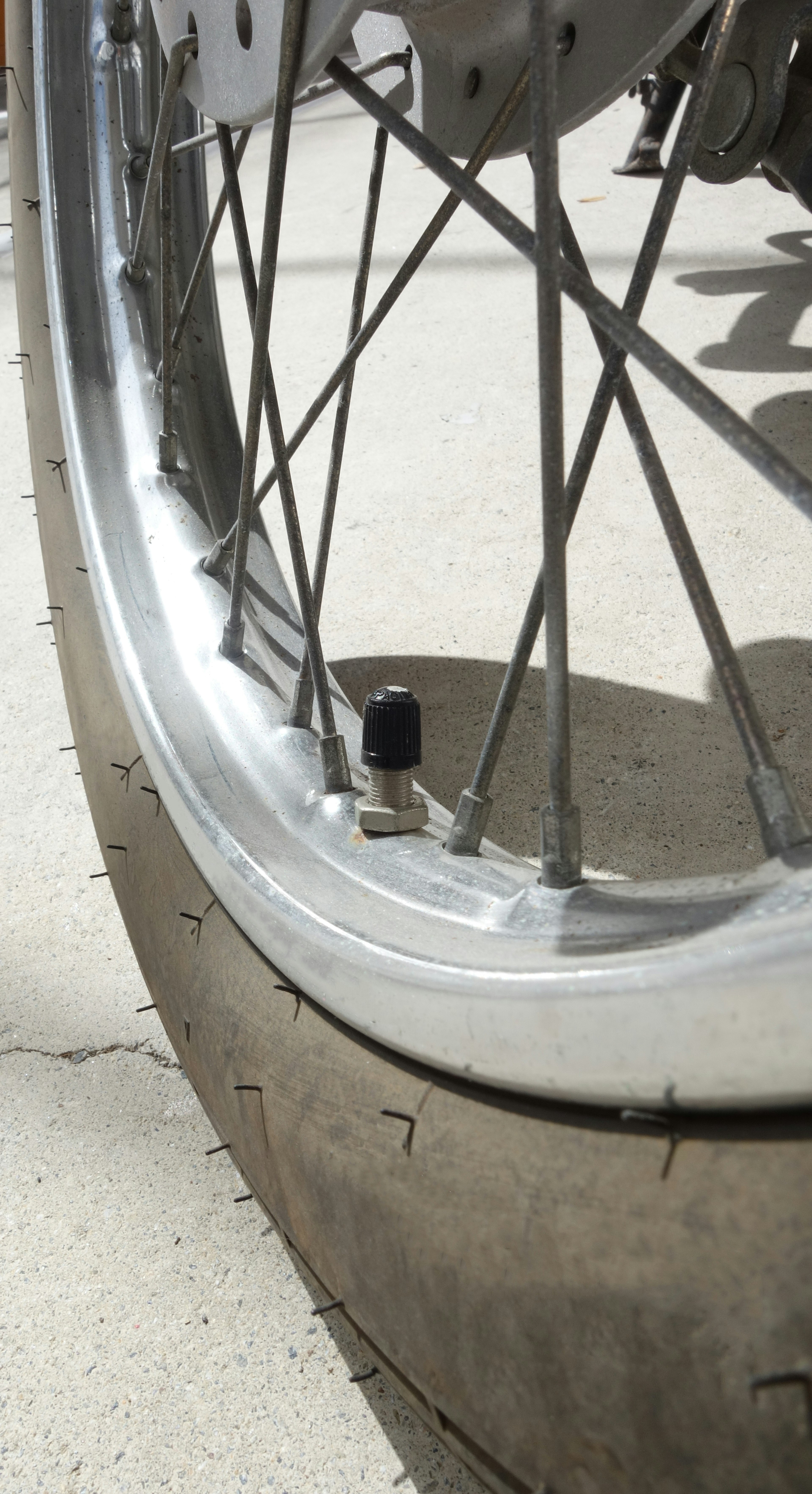 Foto en primer plano de una rueda de motocicleta que muestra radios y detalles del neumático