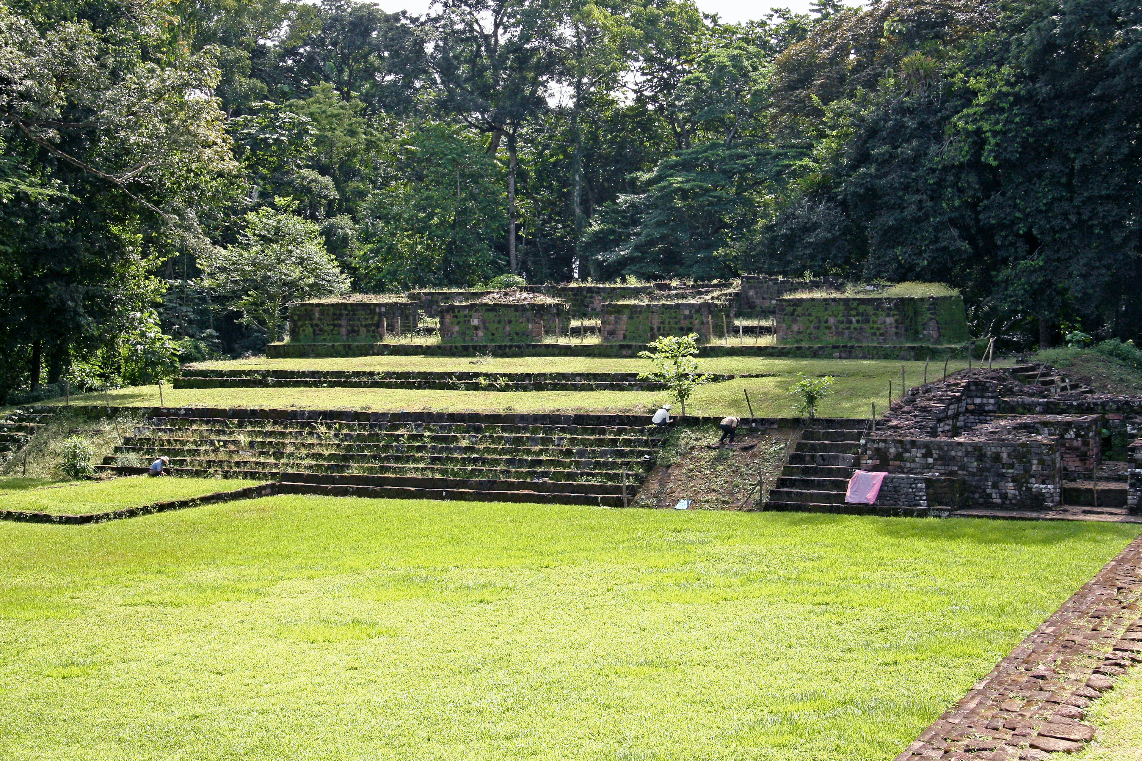 Ancient stepped structure surrounded by lush green grass