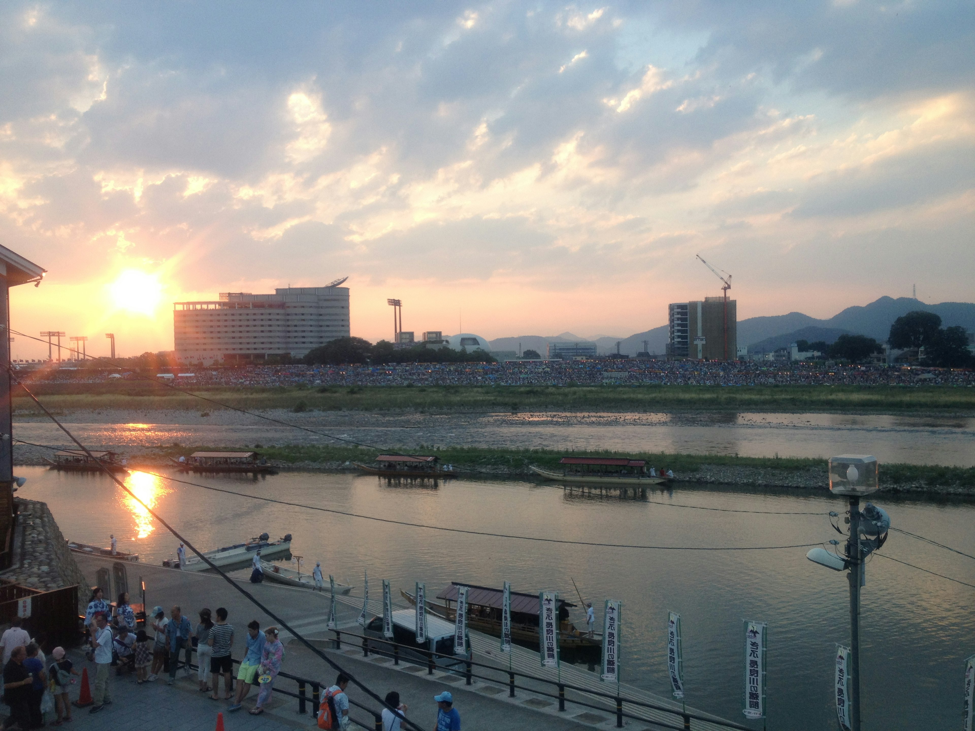 Tramonto che si riflette sul fiume con silhouette di persone