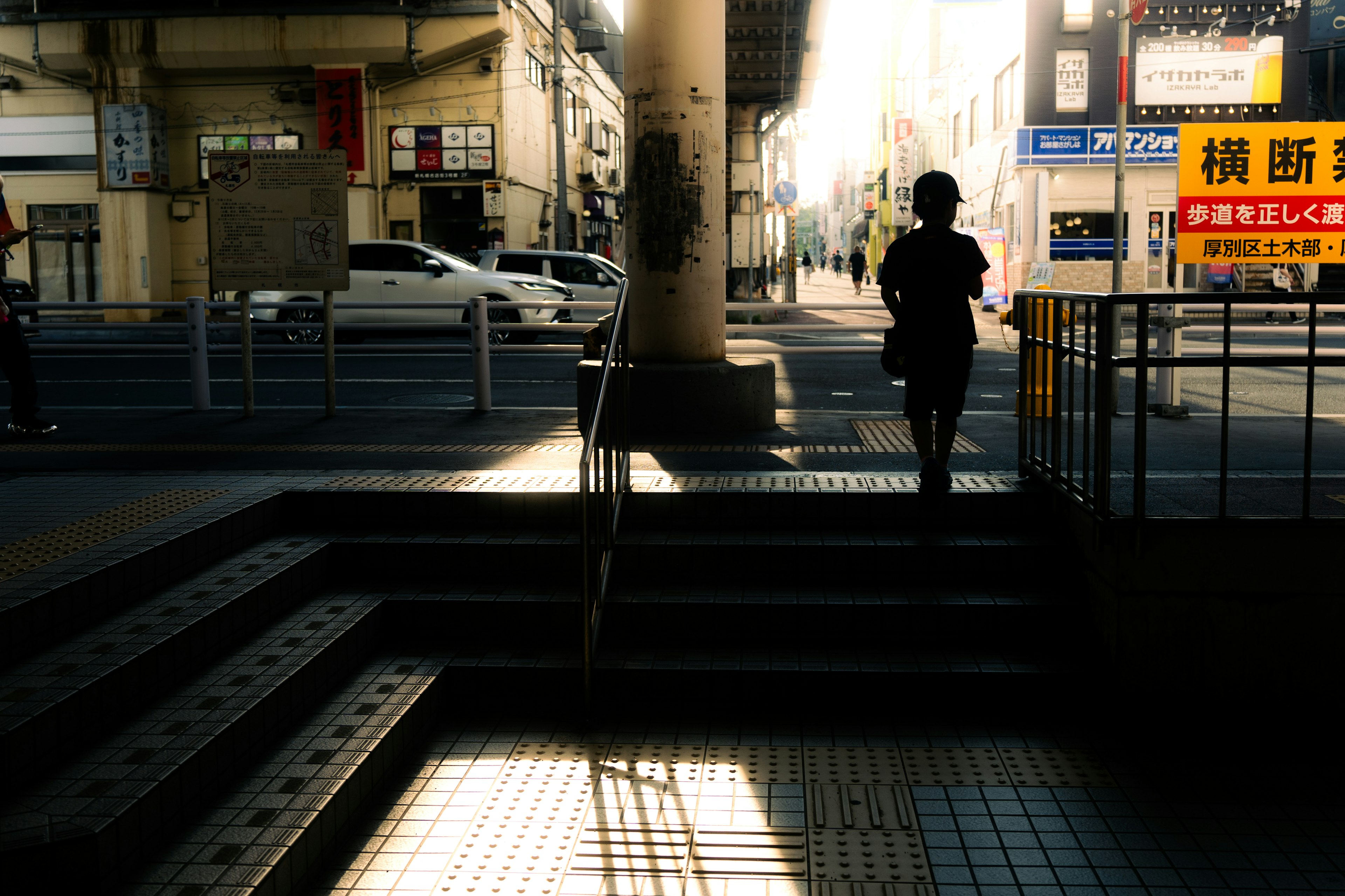 Silueta de una mujer proyectando sombras en una calle iluminada