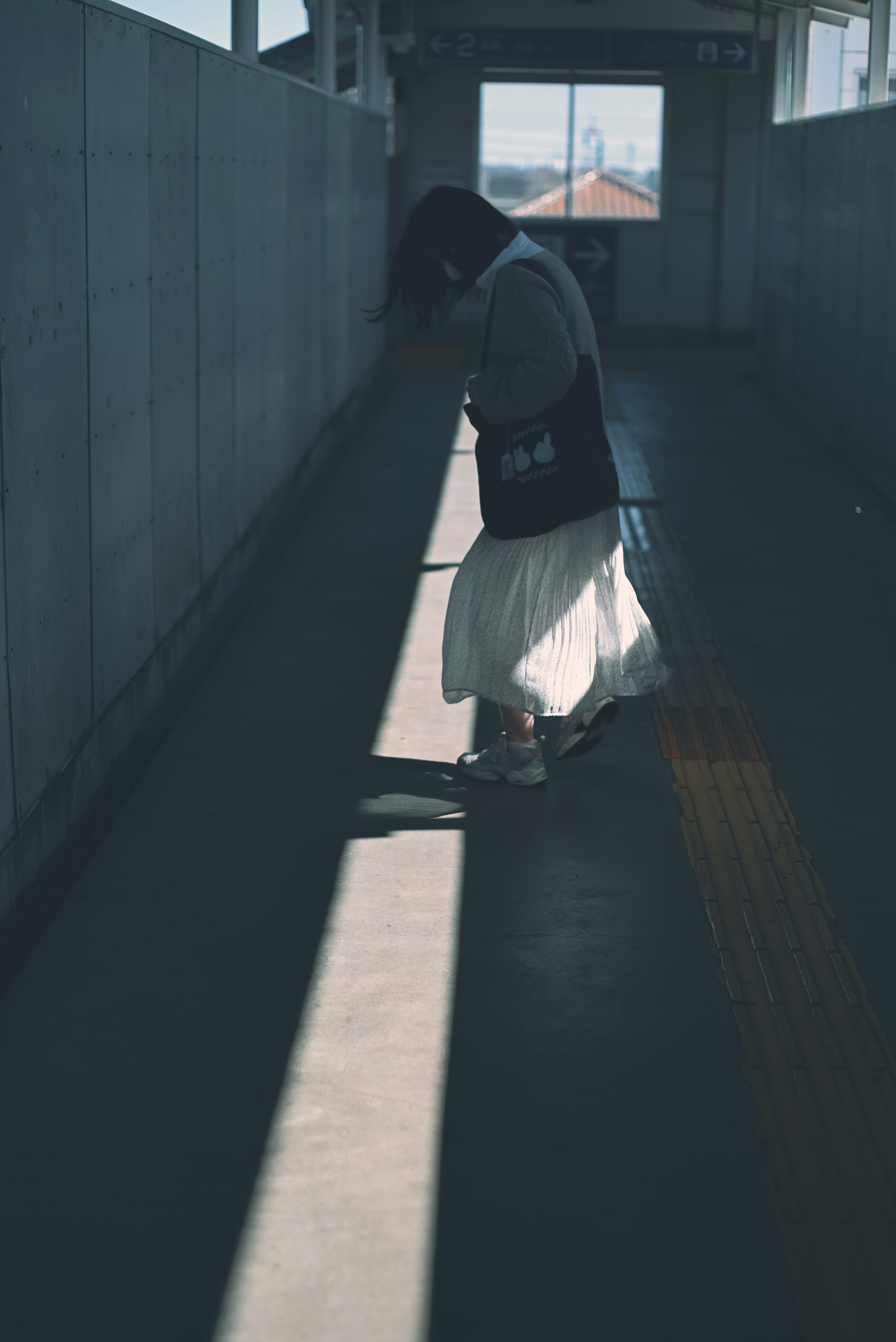 A woman holding an umbrella in a dim corridor