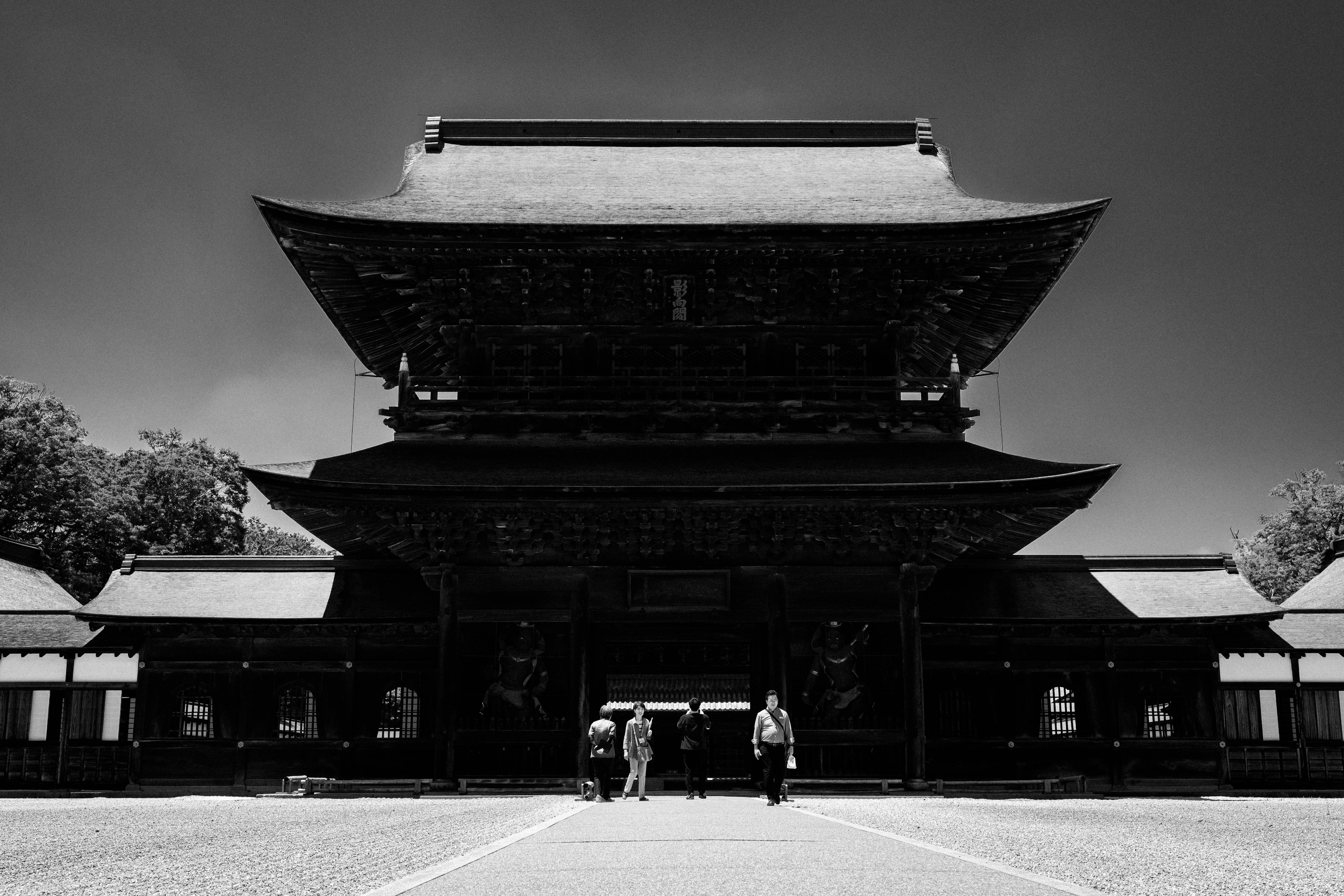 黑白圖像中的歷史寺廟建築和前景中的人