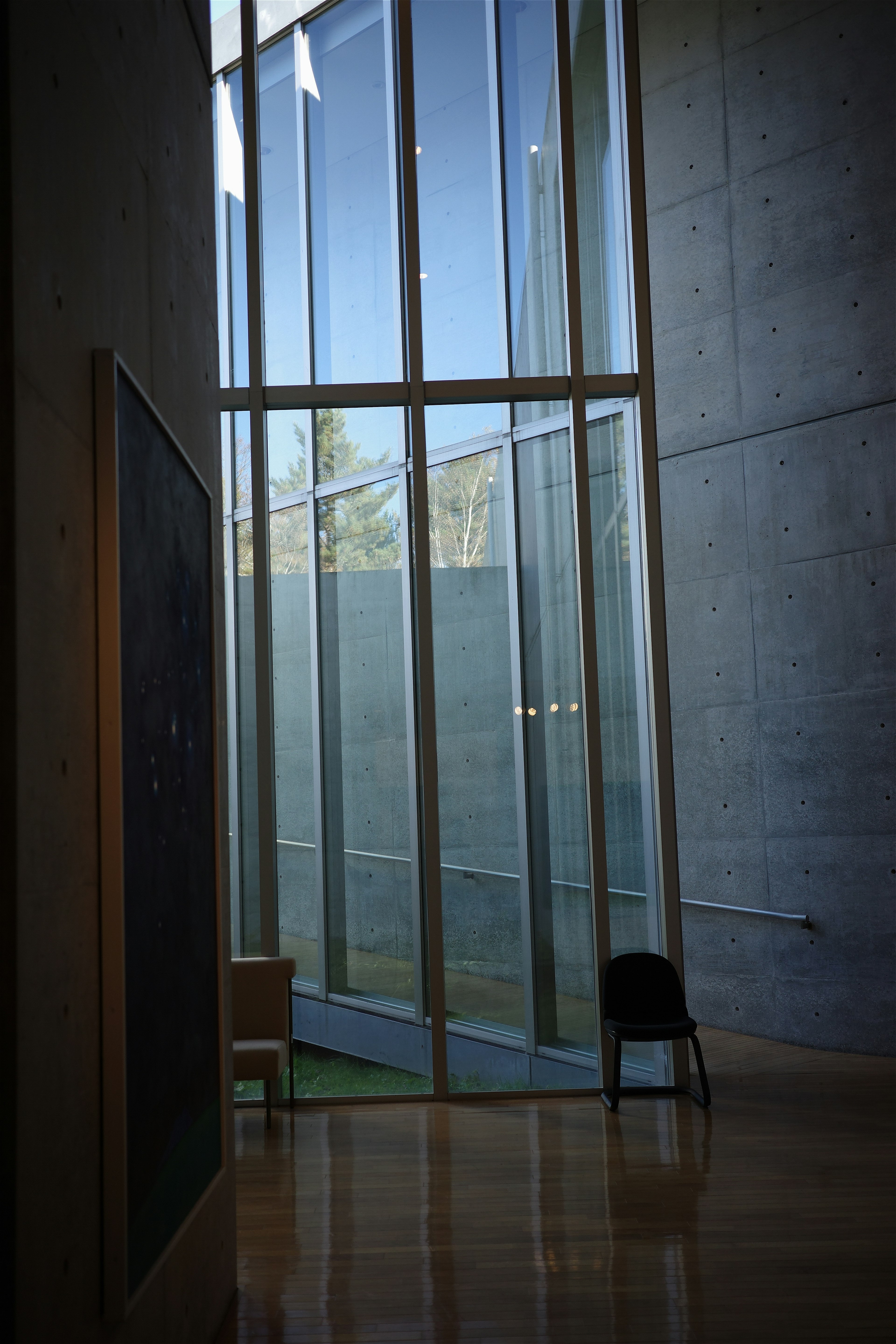 Interior de un espacio moderno con paredes de vidrio brillante y estructura de concreto