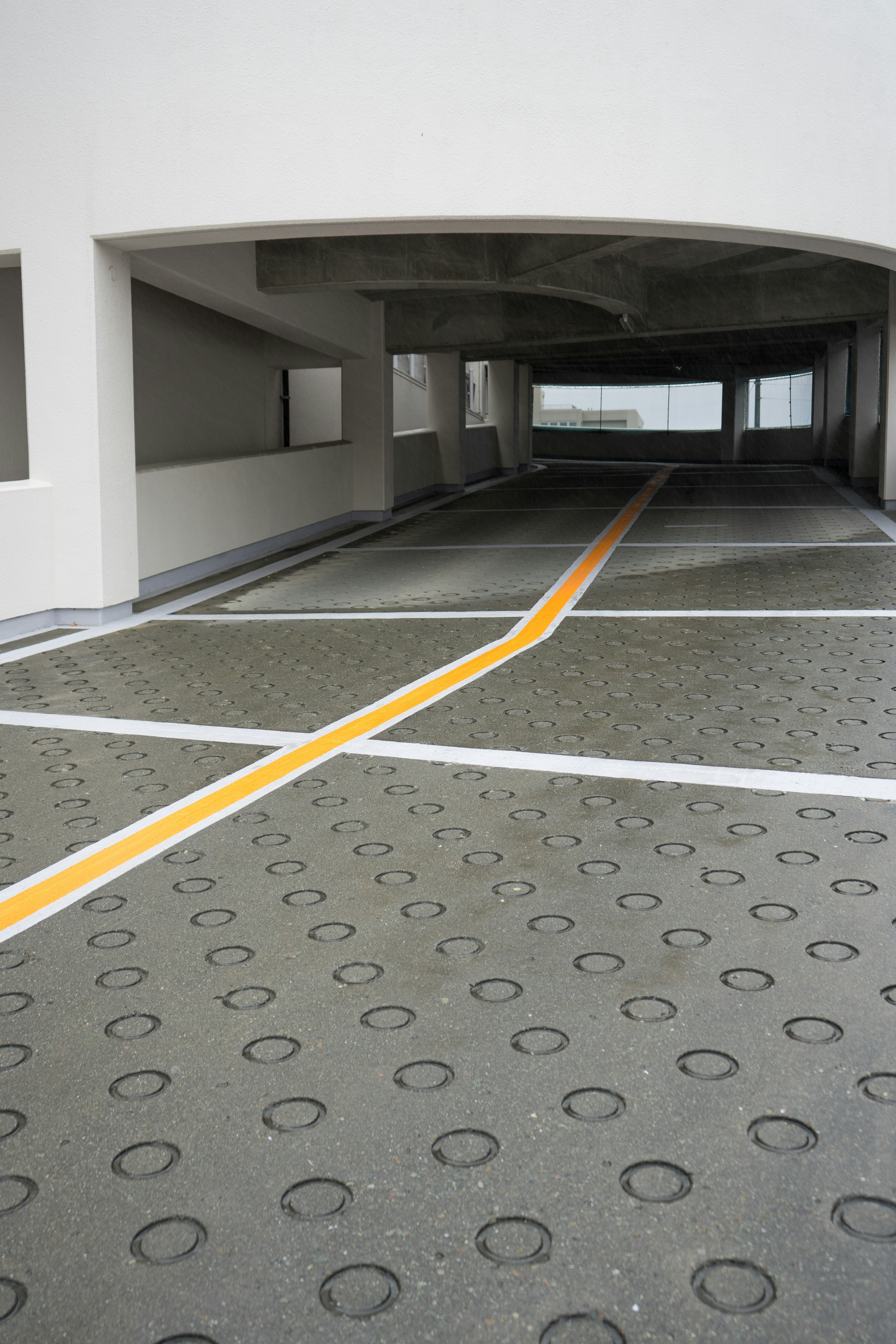 Intérieur d'un garage de stationnement avec une ligne jaune traversant le sol en béton