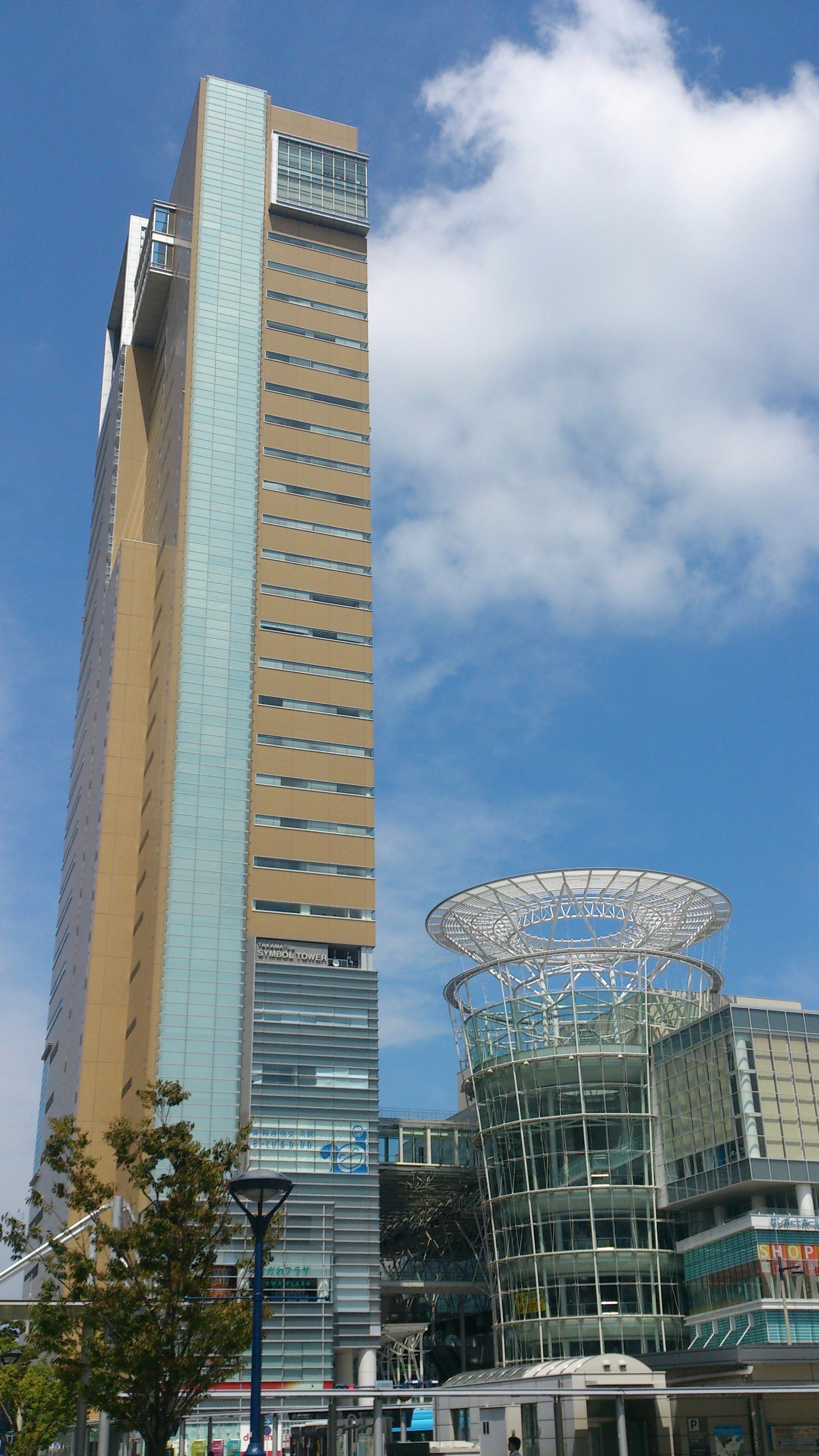 Hoher Wolkenkratzer und modernes Gebäude unter blauem Himmel