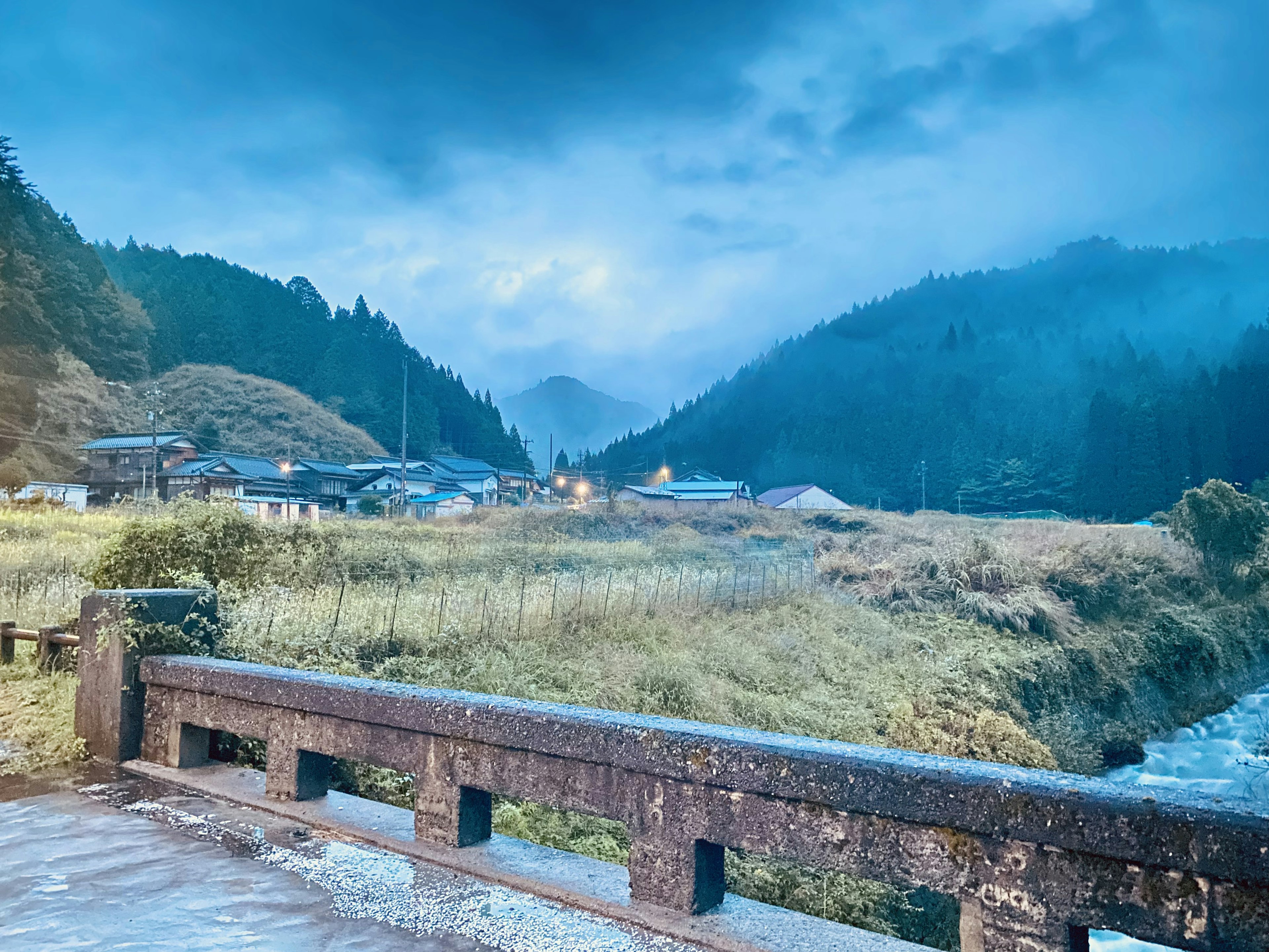 Paesaggio montano con un fiume sotto una nebbia blu