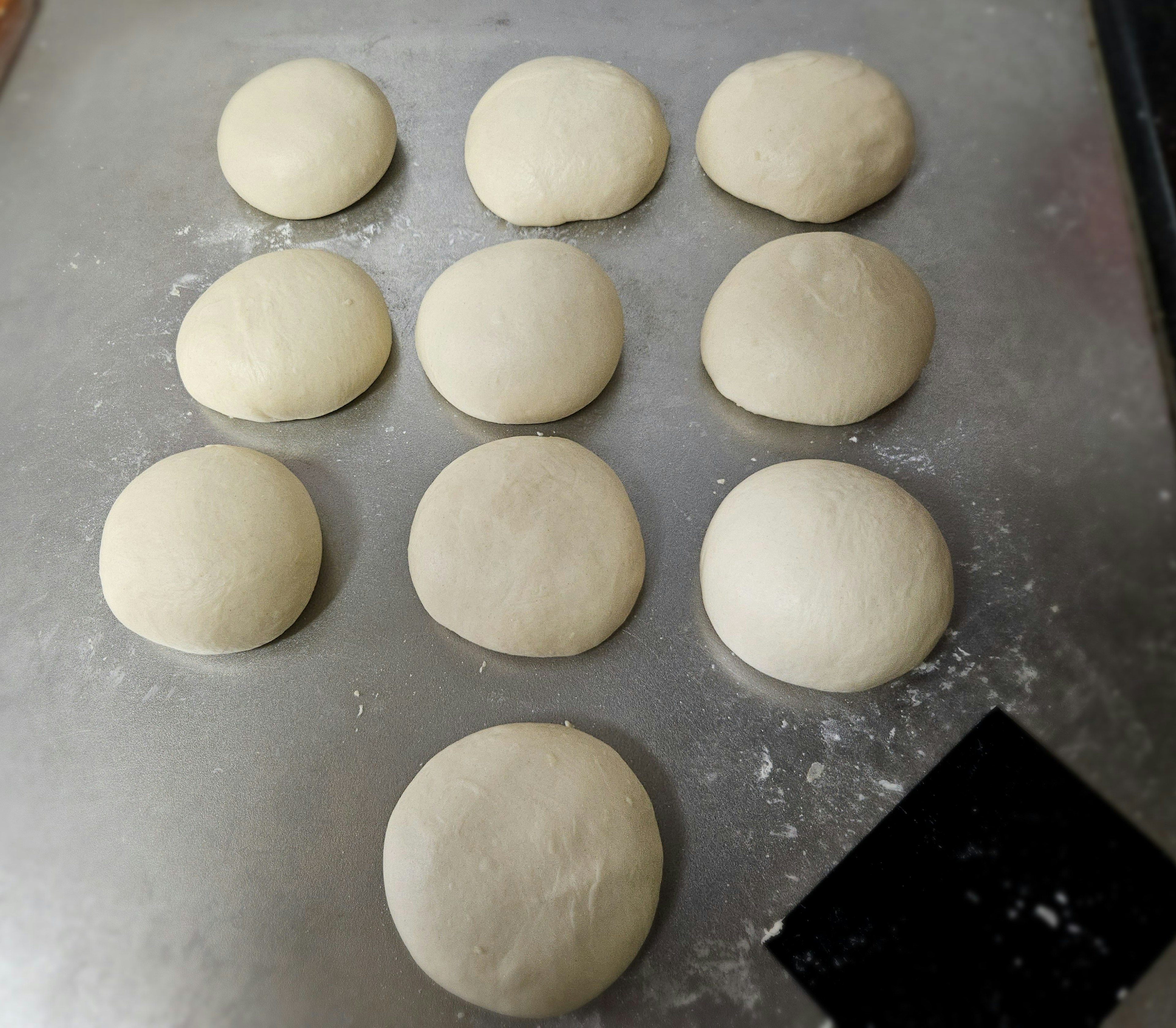 Piezas de masa redondas dispuestas sobre una superficie de horneado