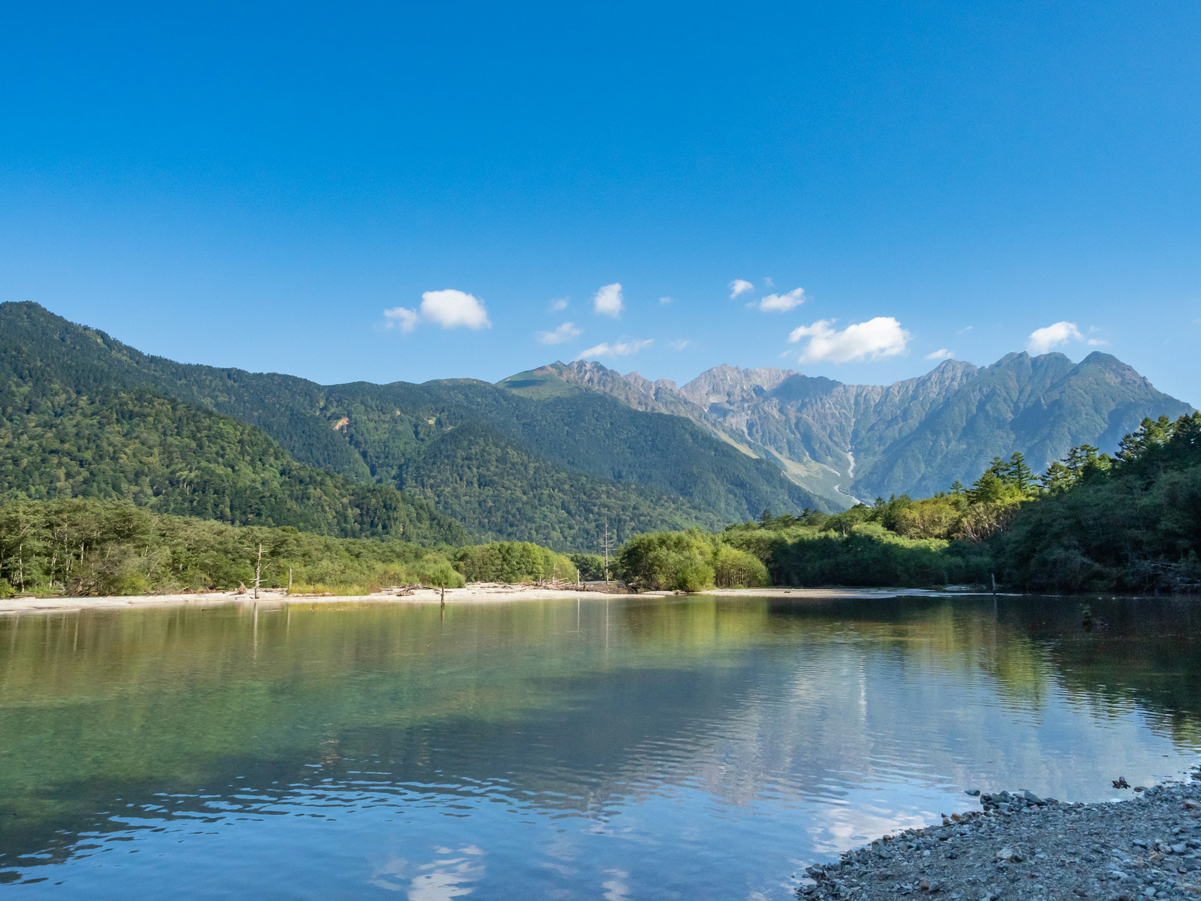 Malersicher Blick auf Berge und klaren Fluss üppiges Grün und blauer Himmel