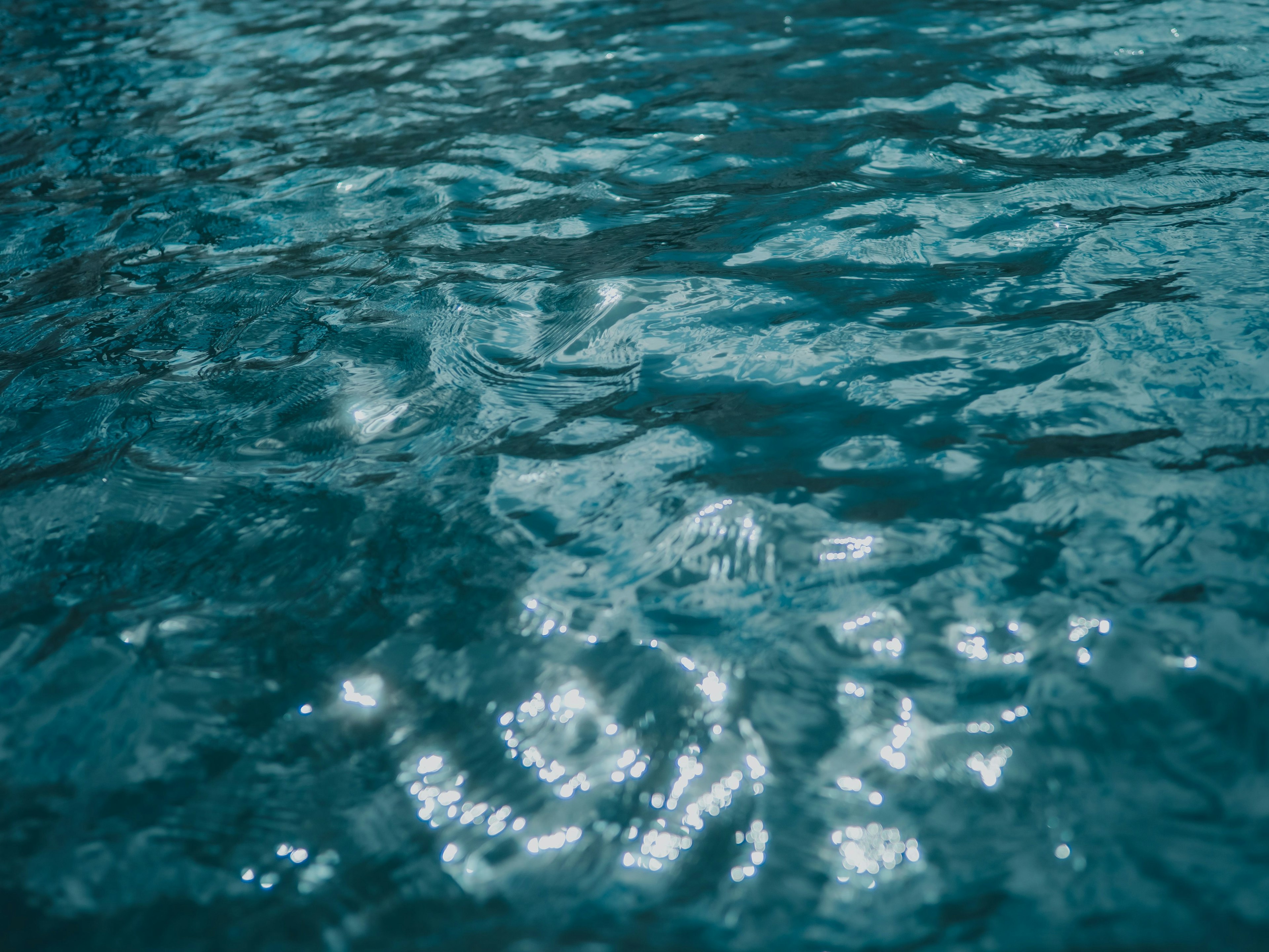 Immagine di acqua blu scintillante con increspature e riflessi