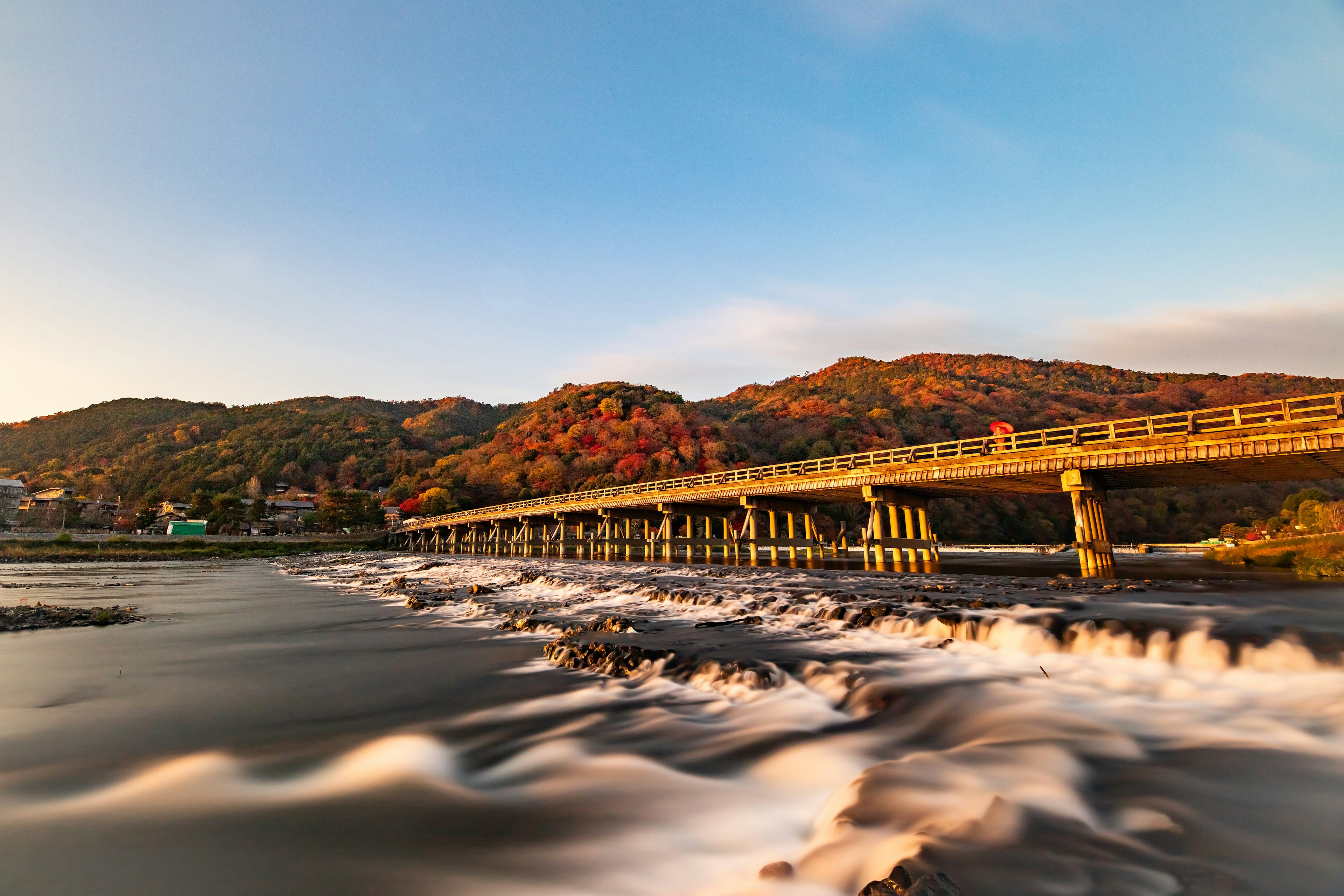 Scenic view of a bridge over a river with autumn foliage