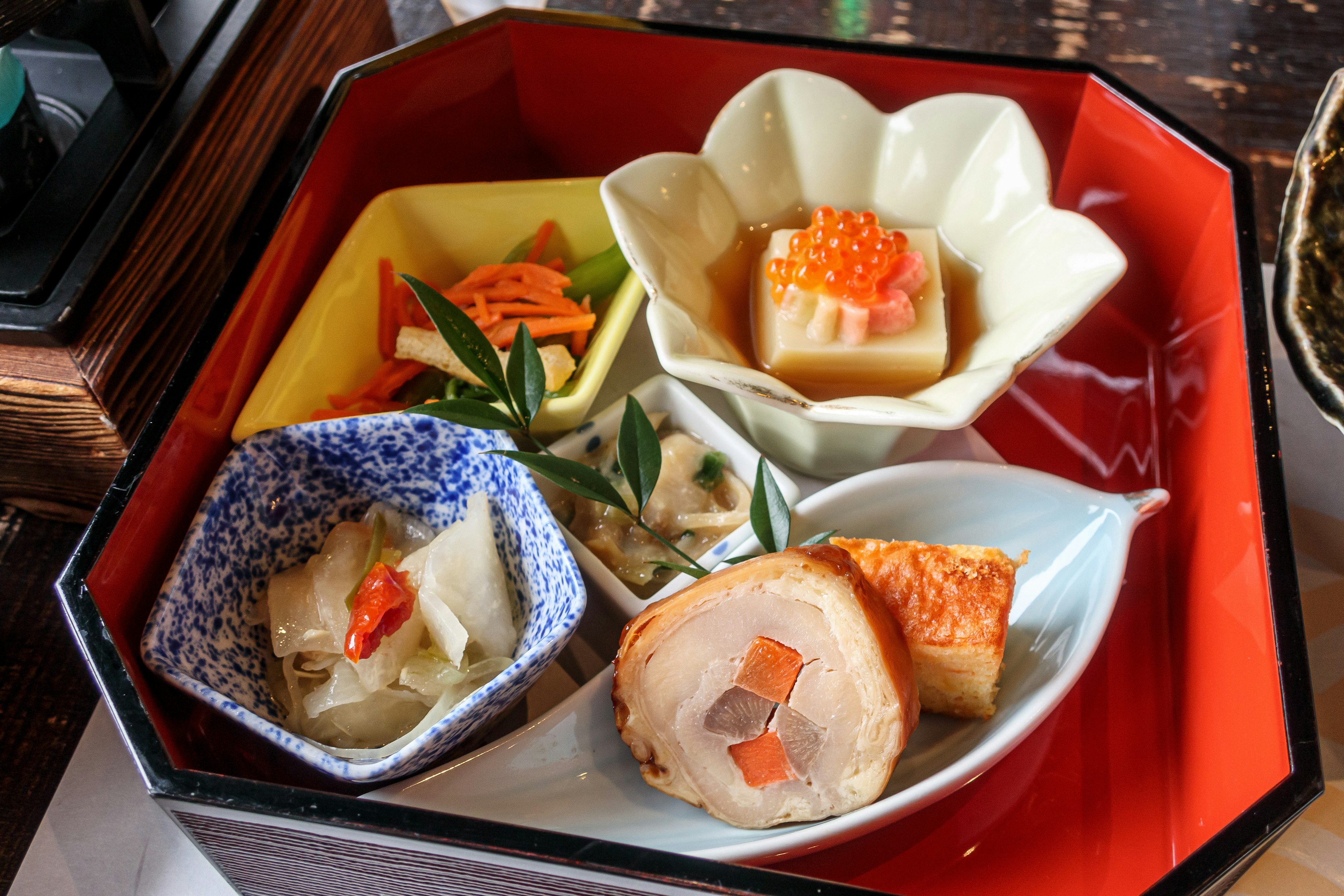 A colorful assortment of Japanese cuisine presented in lacquered dishes