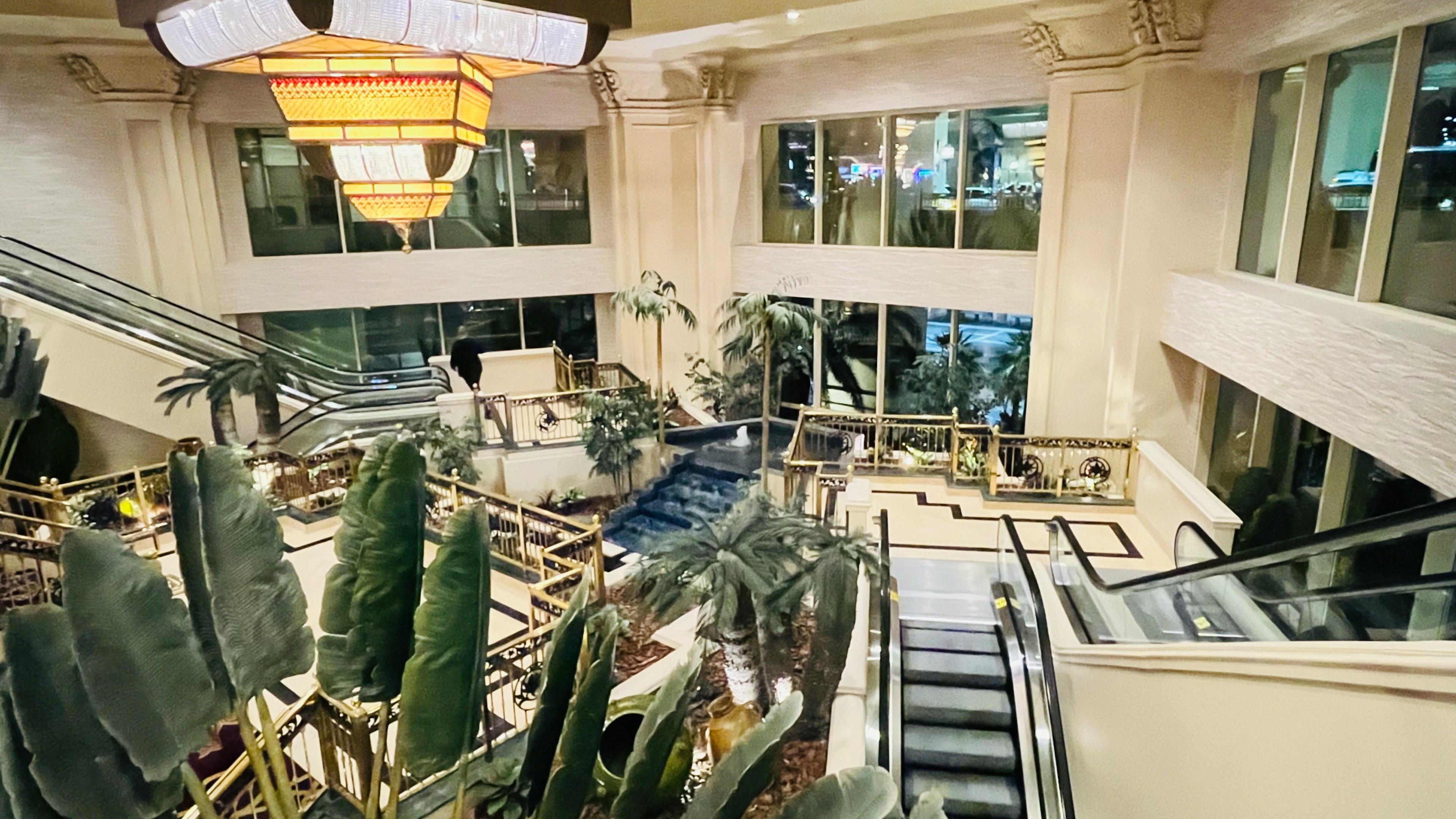 Luxurious lobby featuring escalators and indoor plants