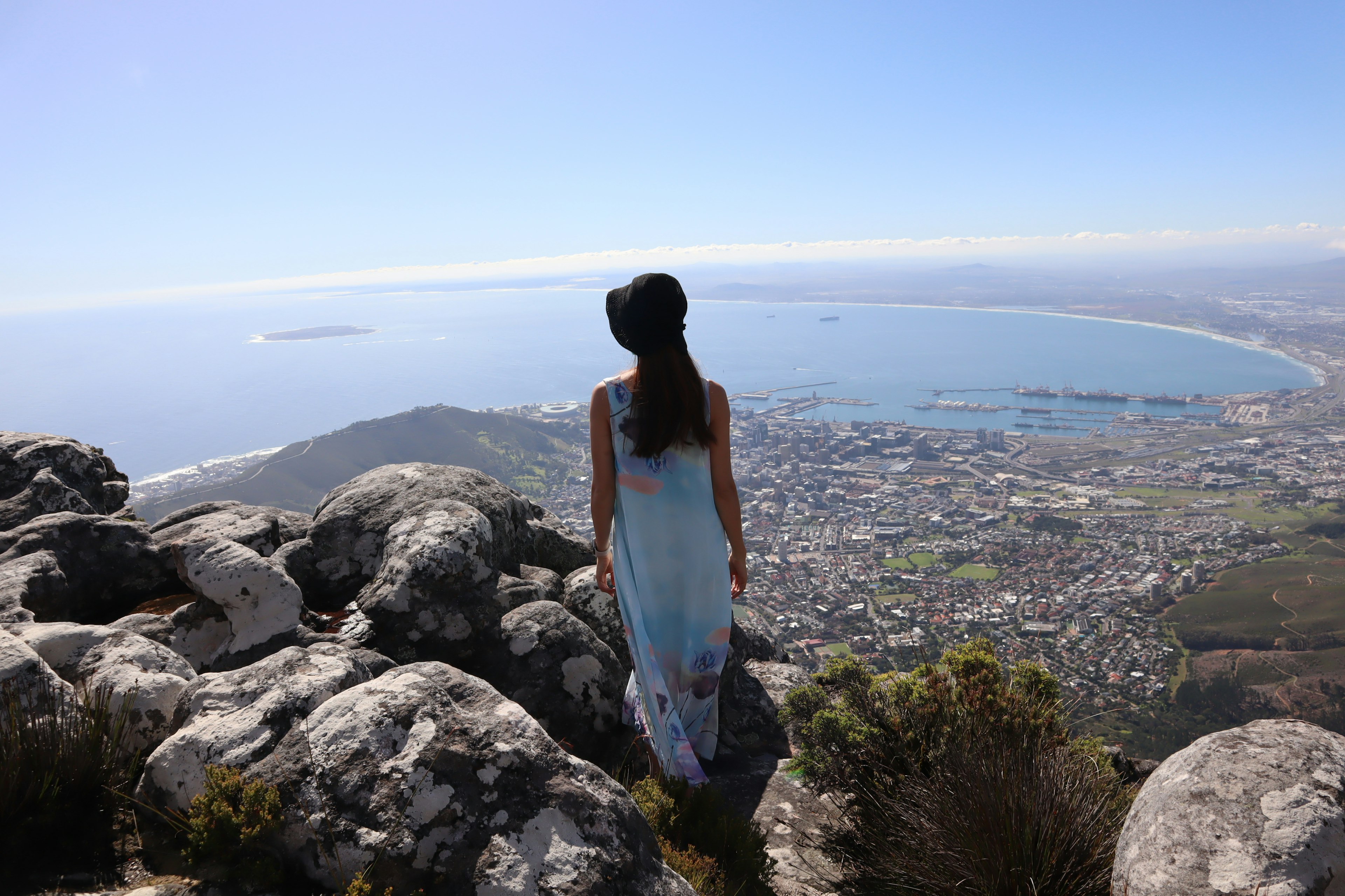 Woman overlooking a scenic view of the ocean and city