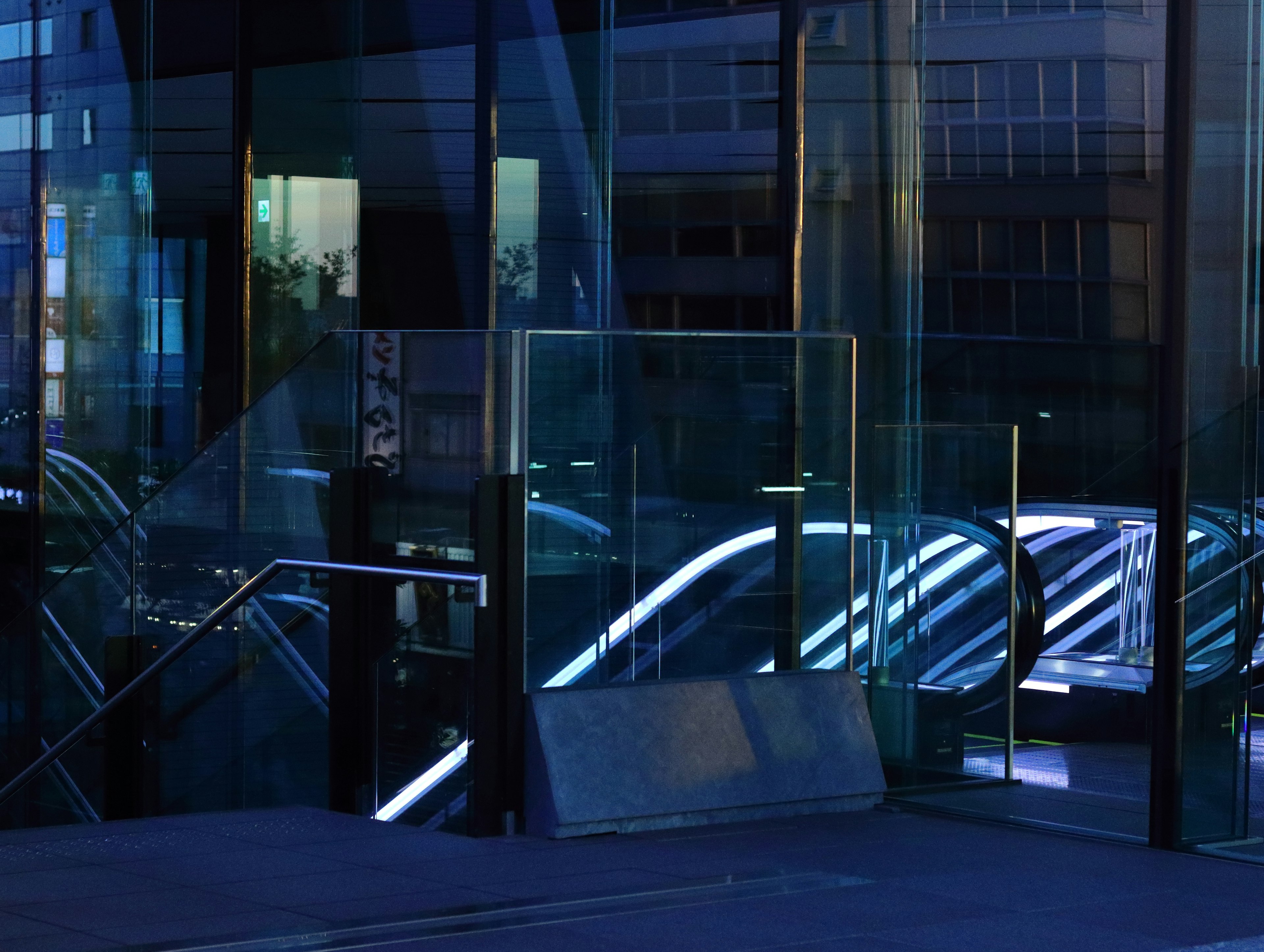 Modern building entrance with glass facade and blue lighting