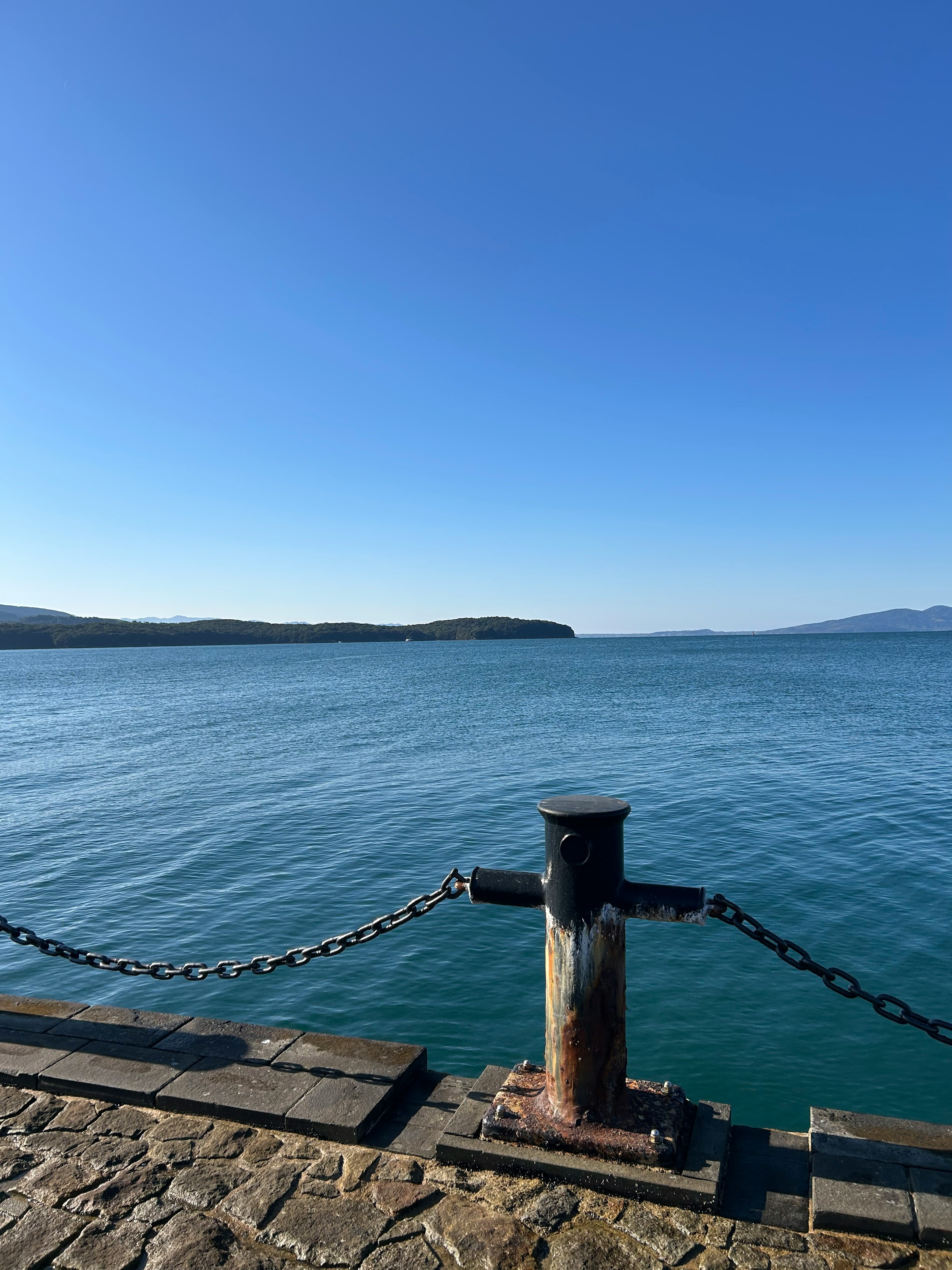 Blick auf einen Kai mit einem Mooring-Pfosten und ruhiger See