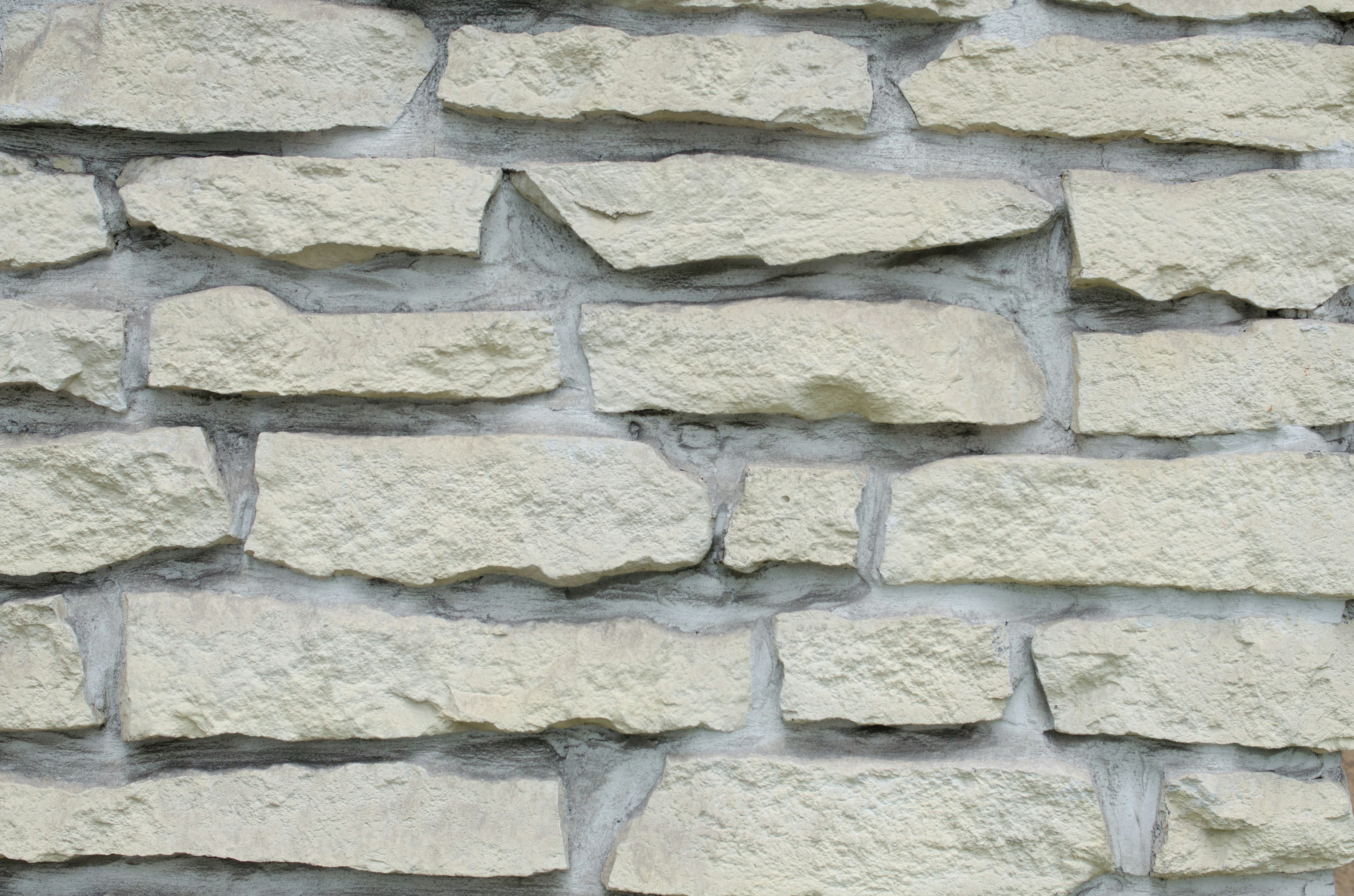 Textured wall of light-colored stone blocks