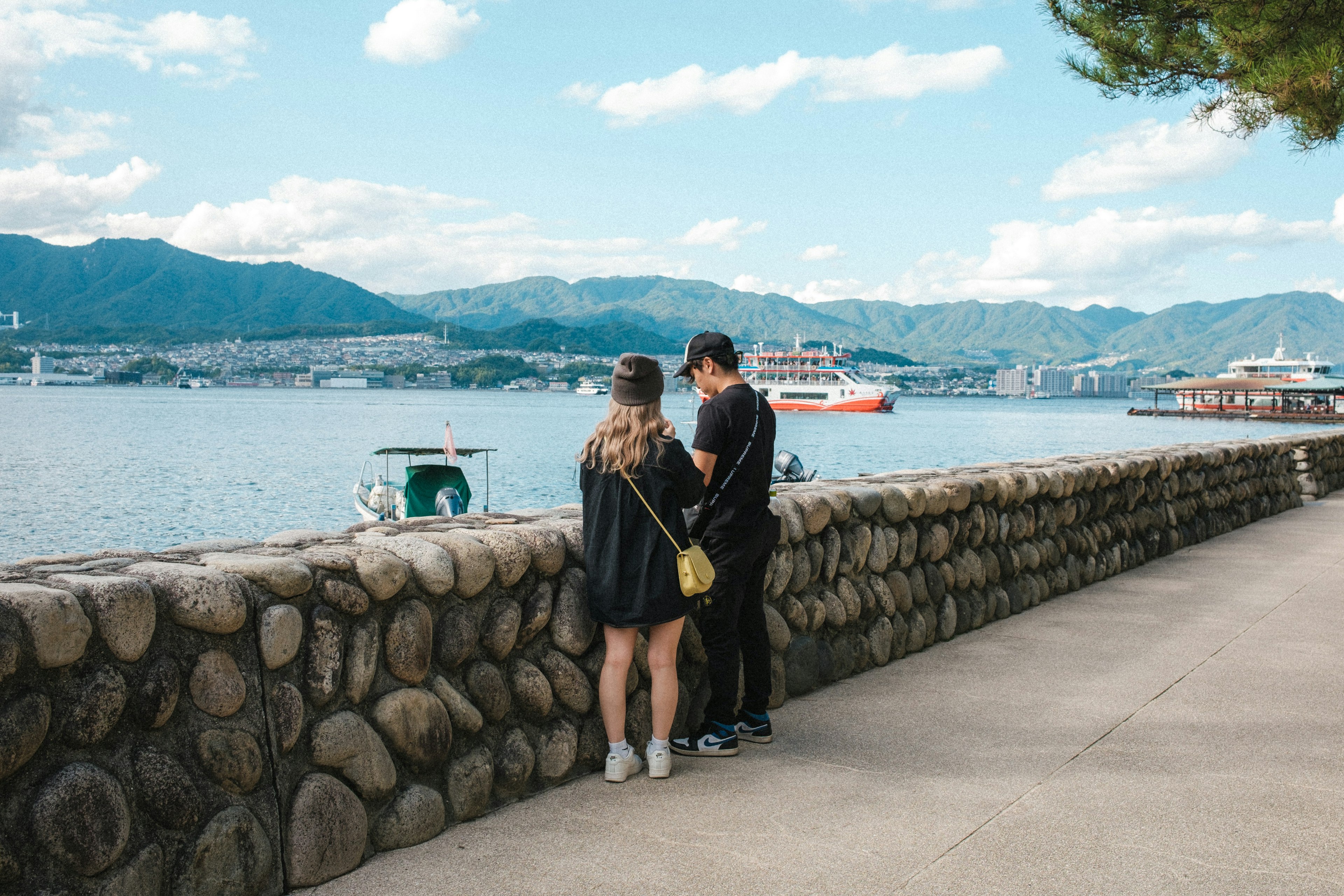 Couple regardant la mer près d'un mur en pierre