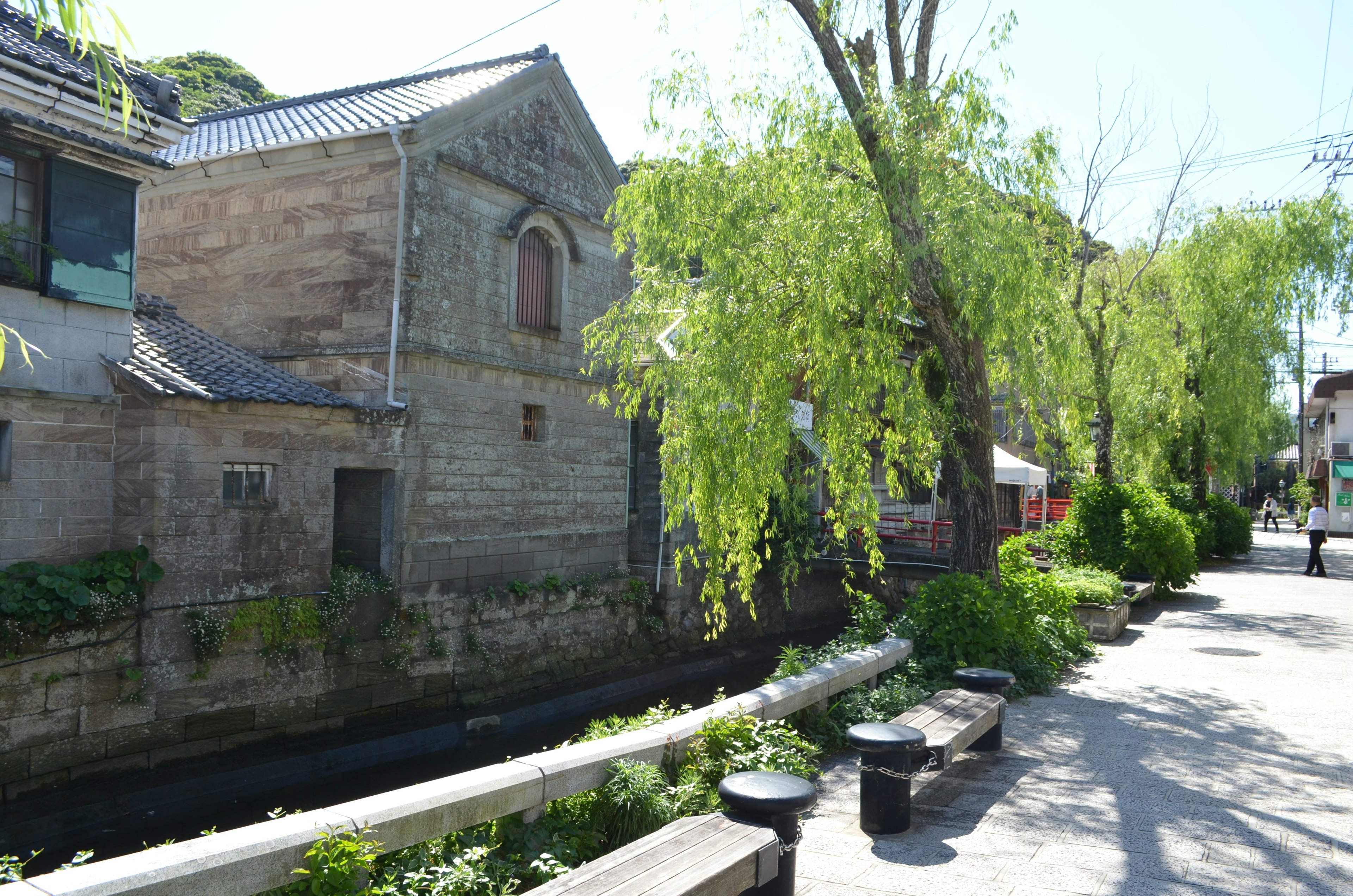 Vue pittoresque d'un vieux bâtiment au bord d'une rivière avec des saules