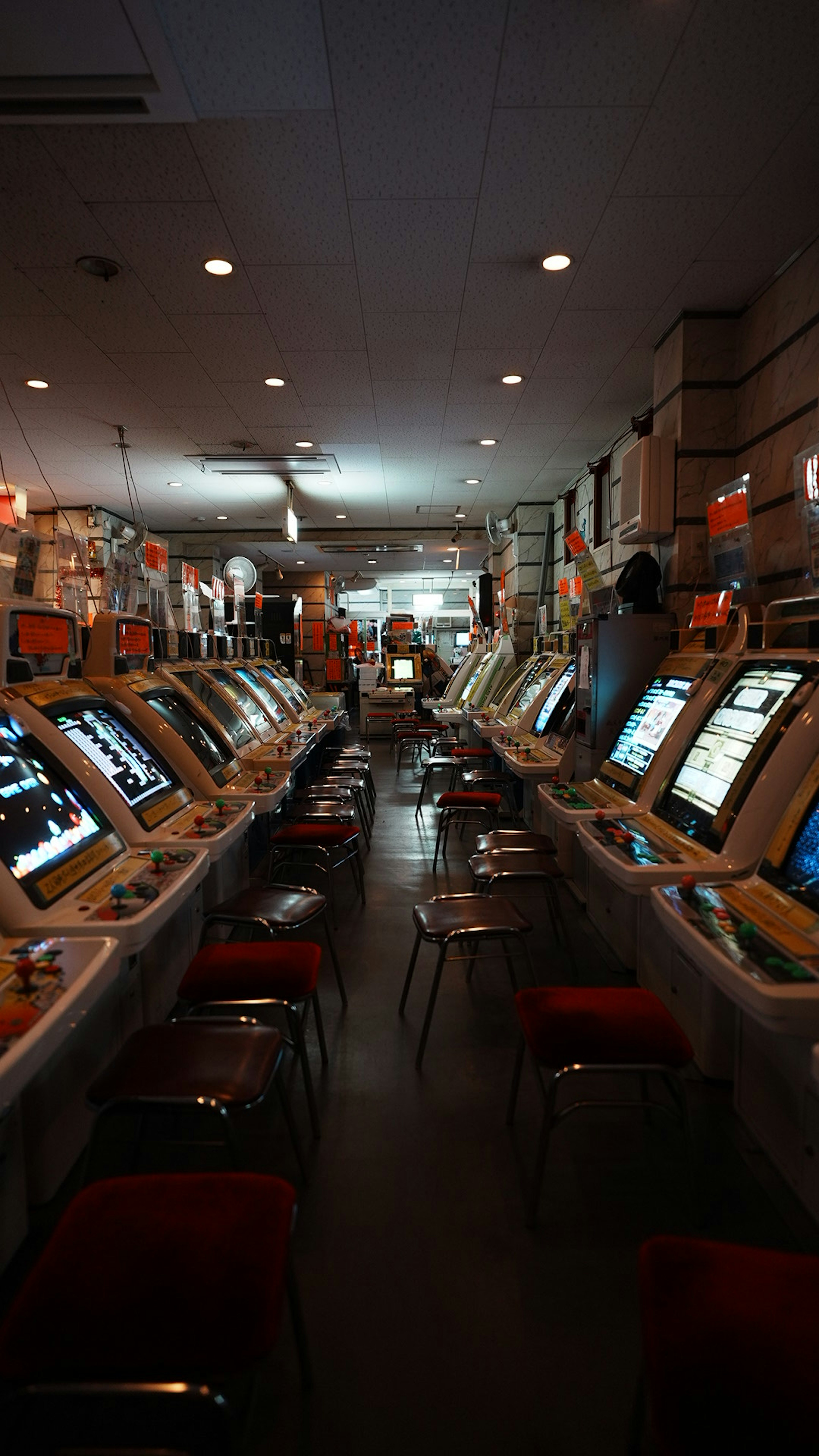 Interior de un casino con filas de máquinas tragamonedas iluminación brillante y sillas rojas