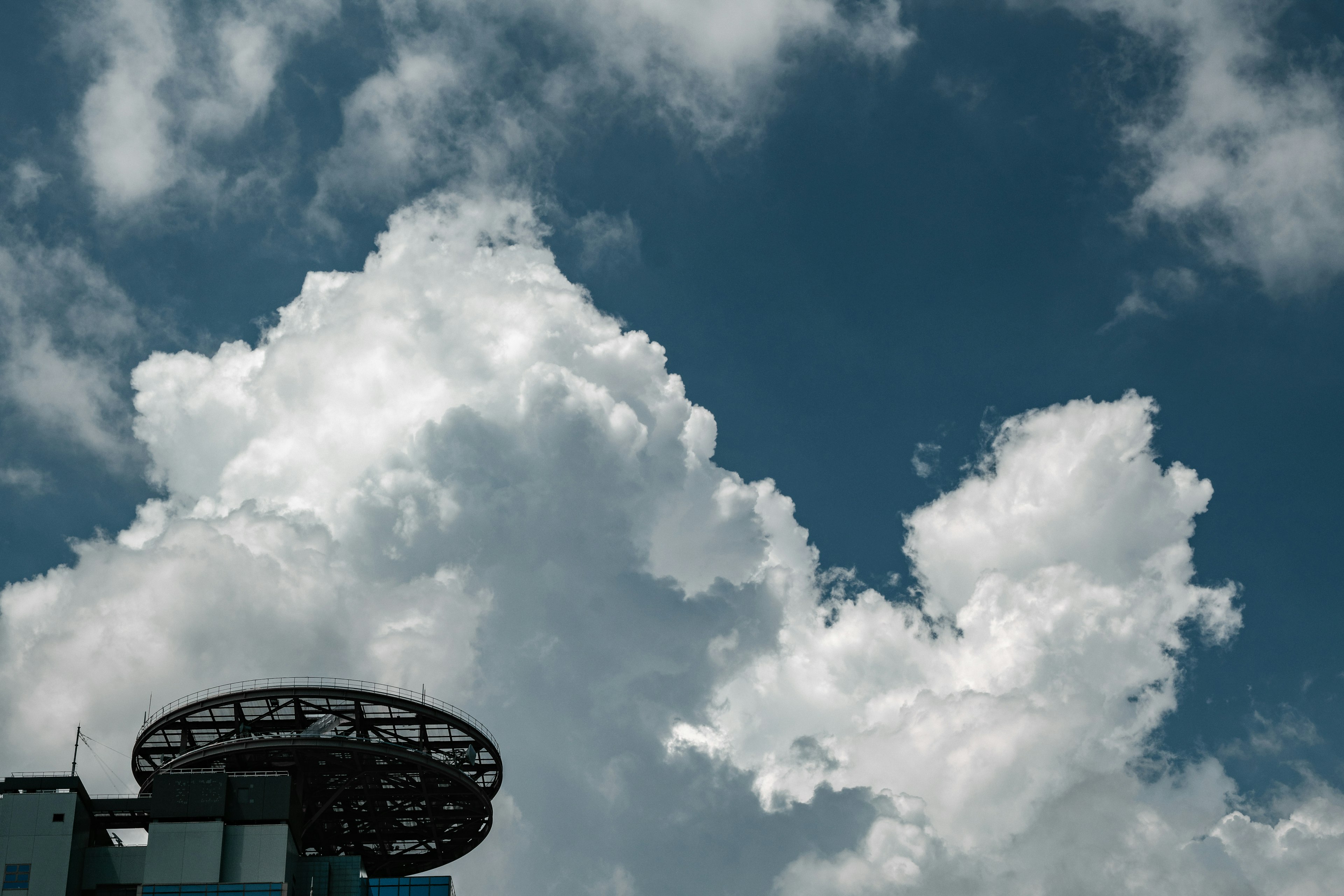 青空に白い雲が浮かぶ風景と建物の一部