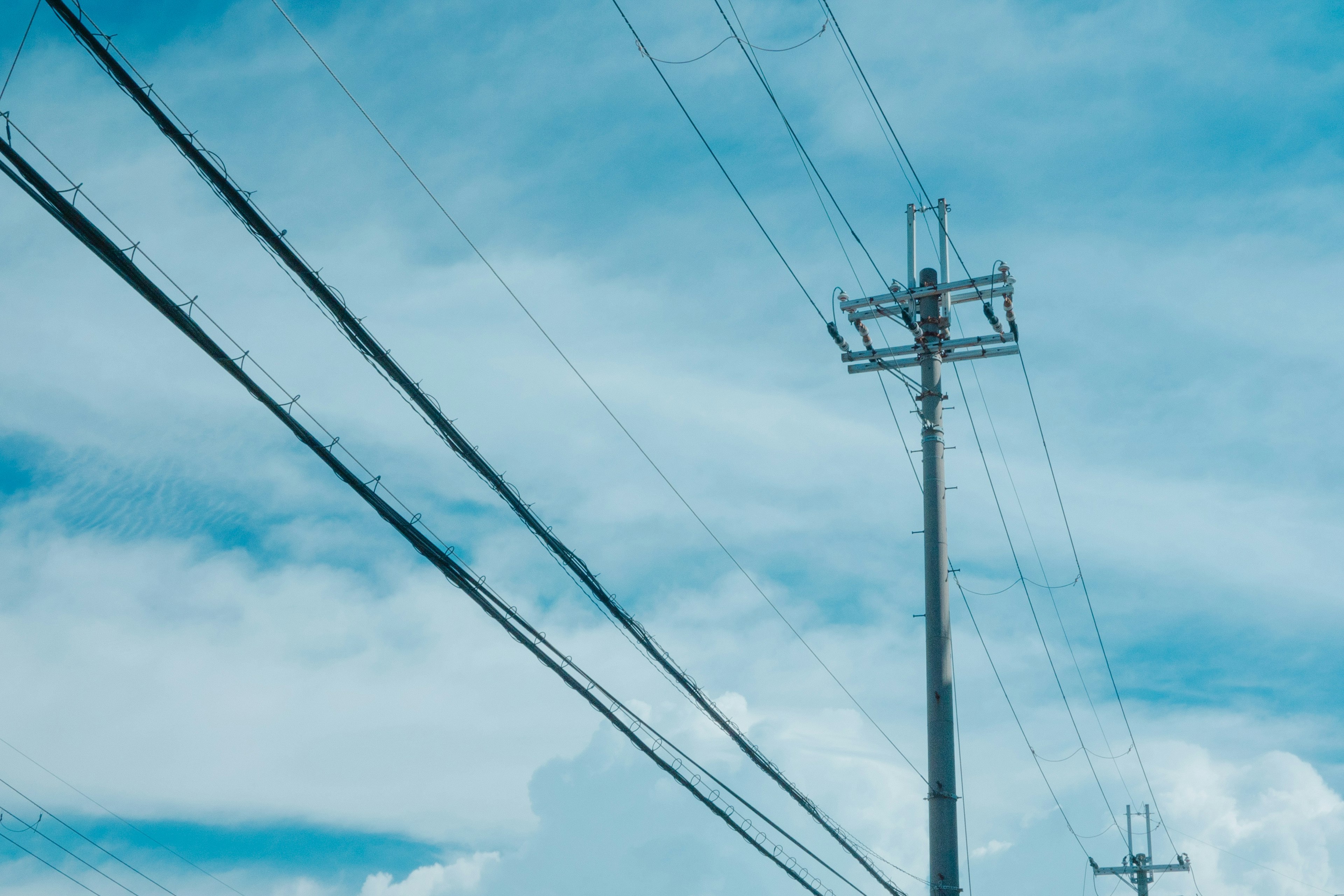 Linee elettriche e palo della luce contro un cielo blu