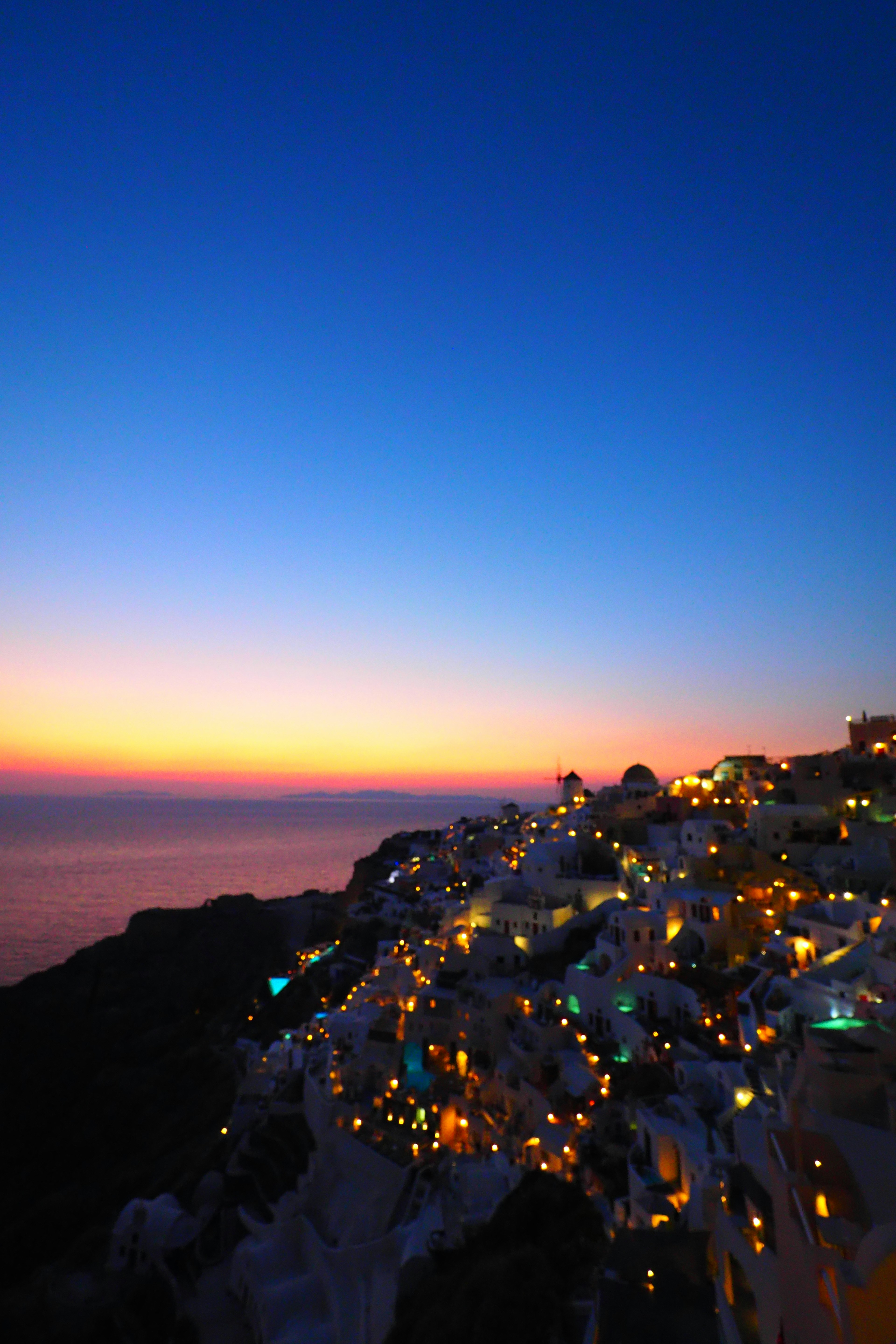 Schöne Nachtansicht der Küste von Santorin mit blauem Himmel und Sonnenuntergangstönen