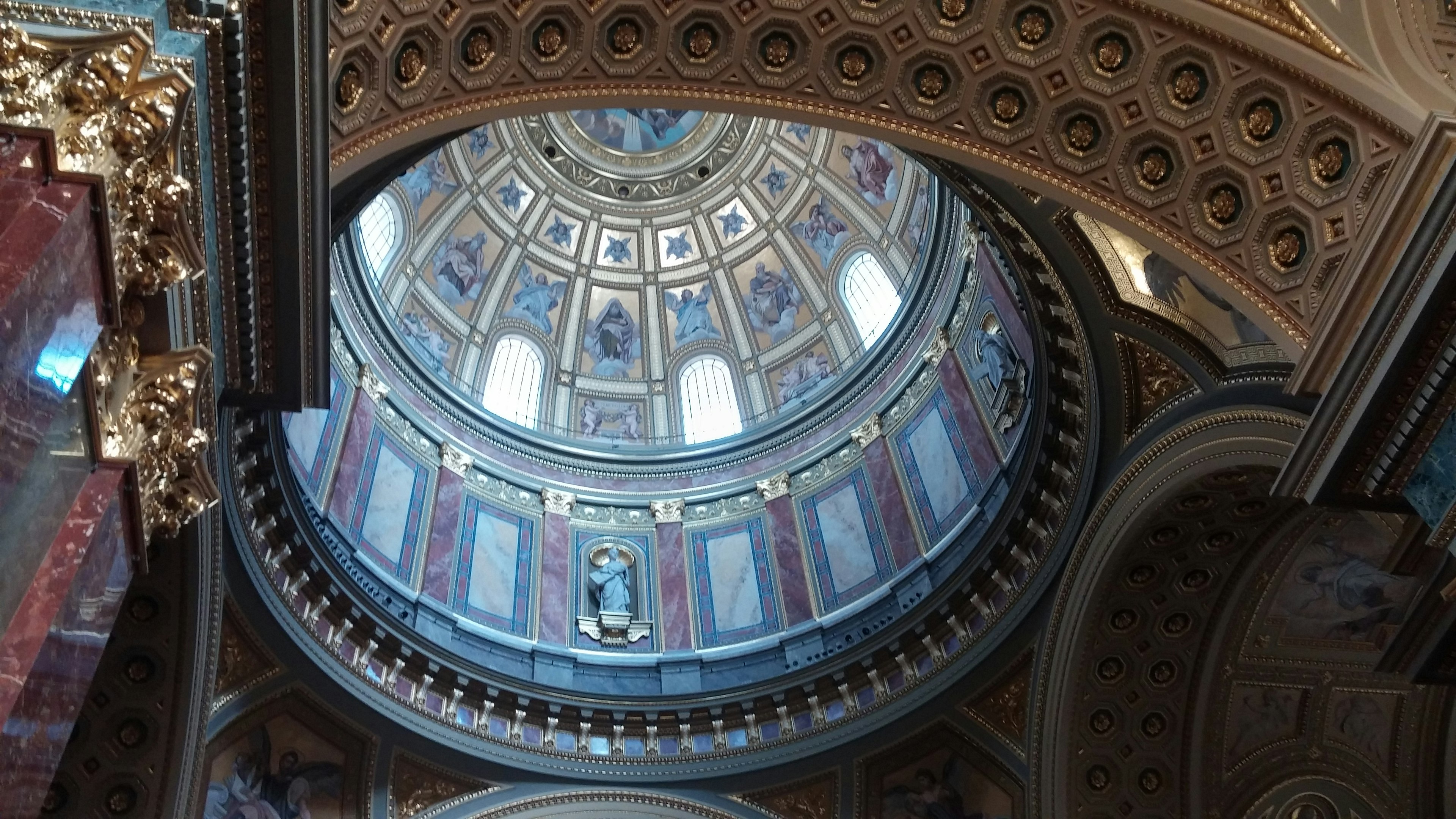 Vista interior de la cúpula de la Basílica de San Pedro mostrando diseños intrincados y frescos