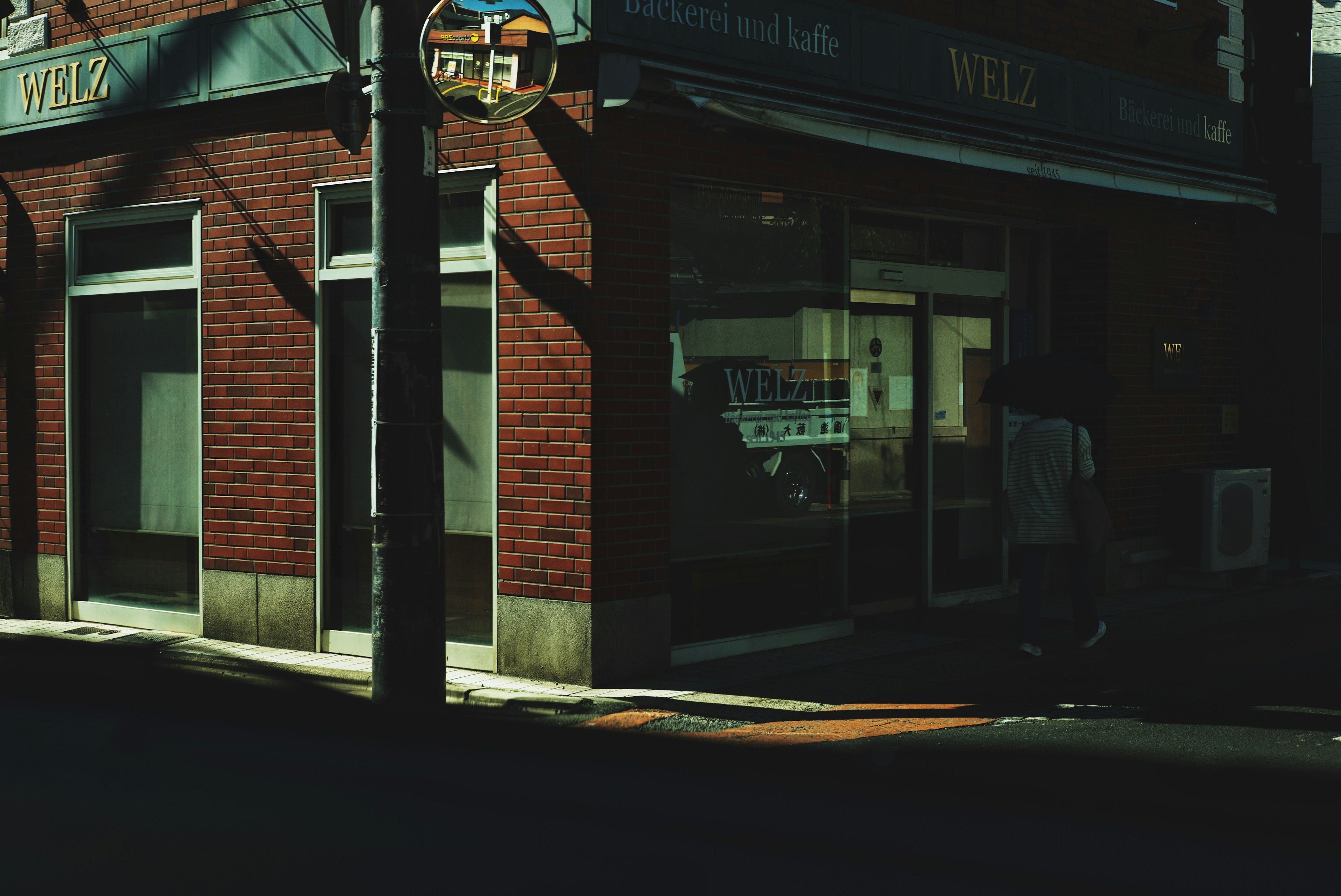 Red brick building on a dark street corner with a sign