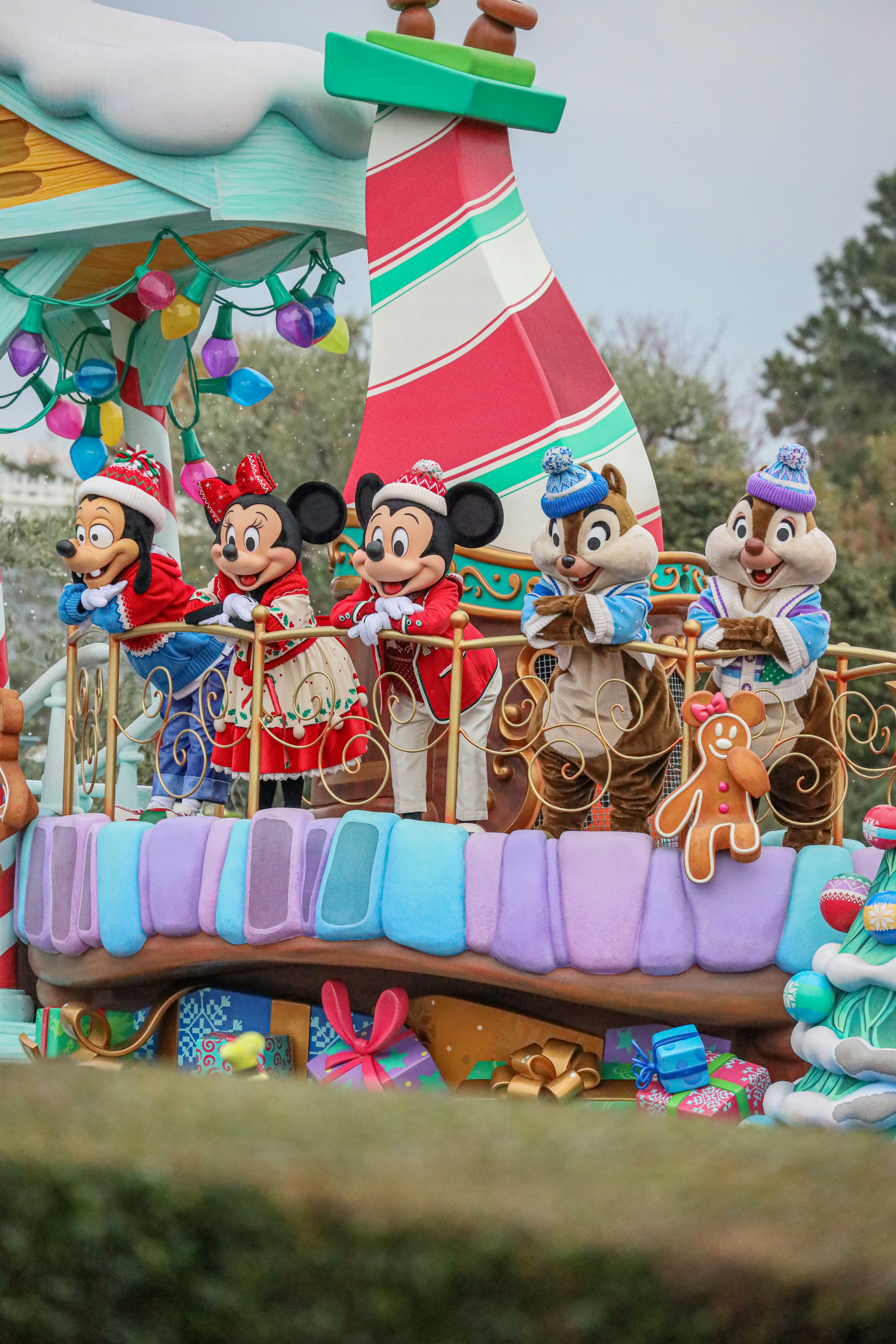 Personajes de Mickey y Minnie en un carro colorido durante un desfile festivo