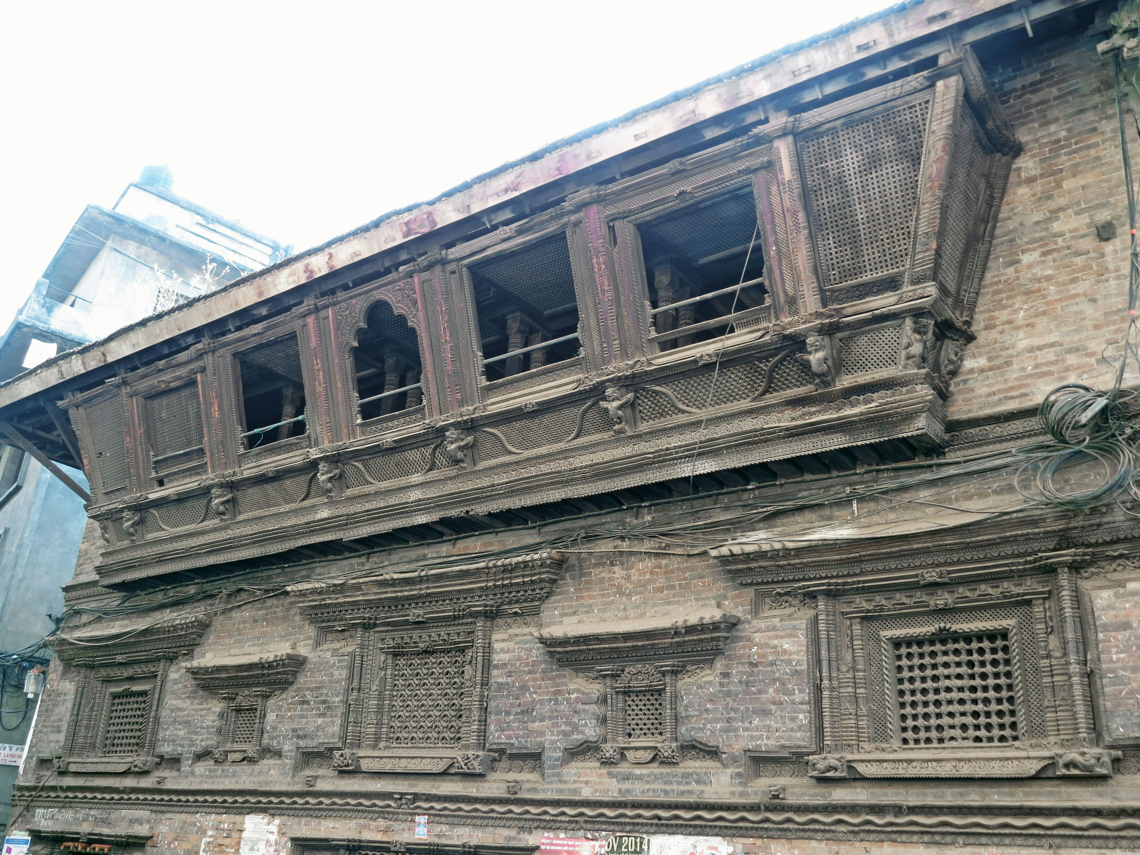 Ancien bâtiment népalais avec balcon en bois et sculptures